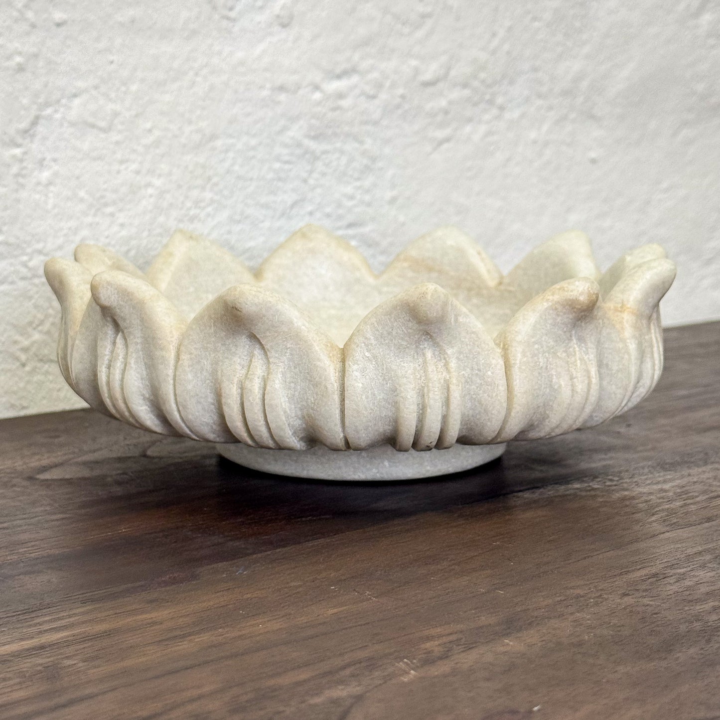 Decorative ceramic bowl with a textured surface on a wooden surface.