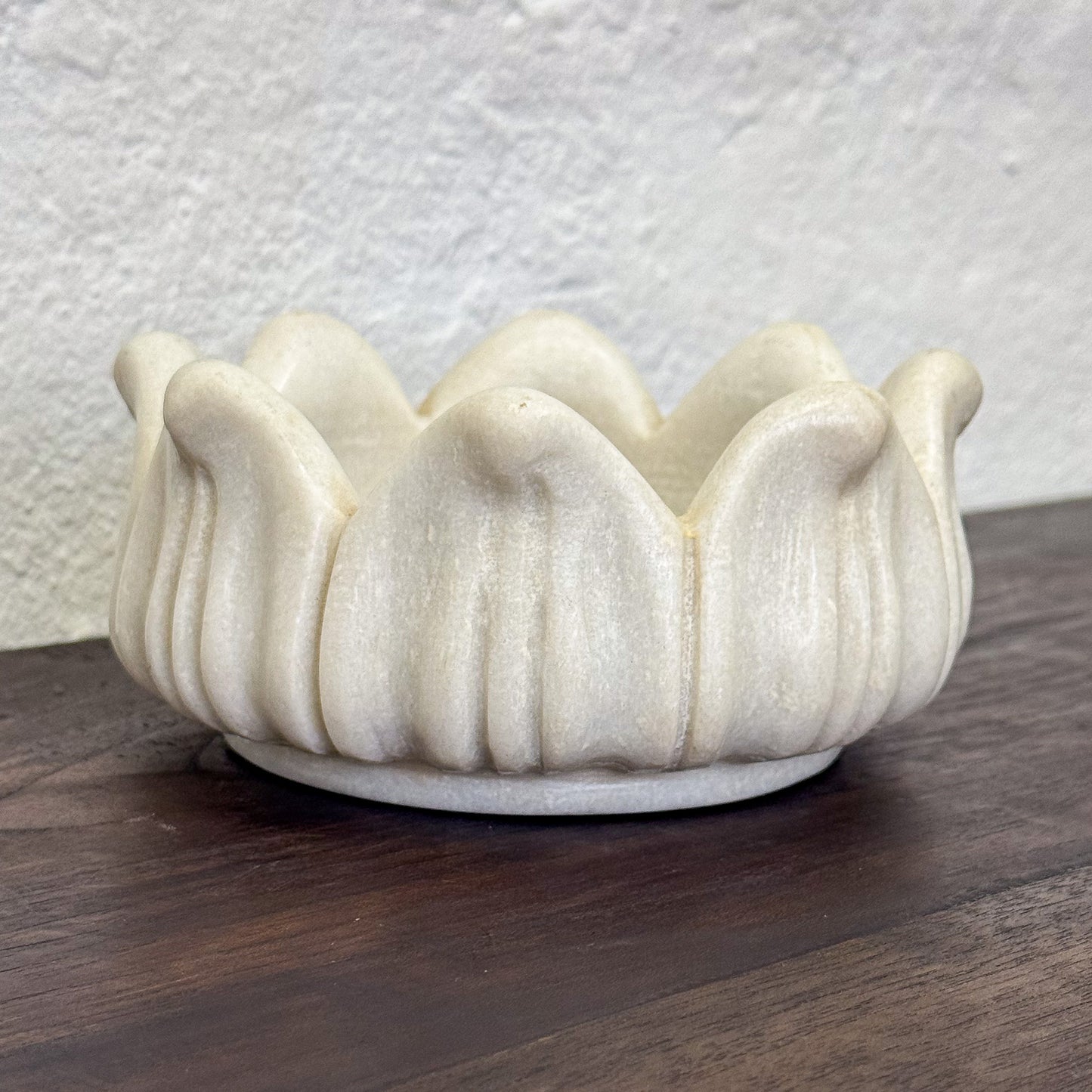 White ceramic bowl with wavy design on a wooden surface
