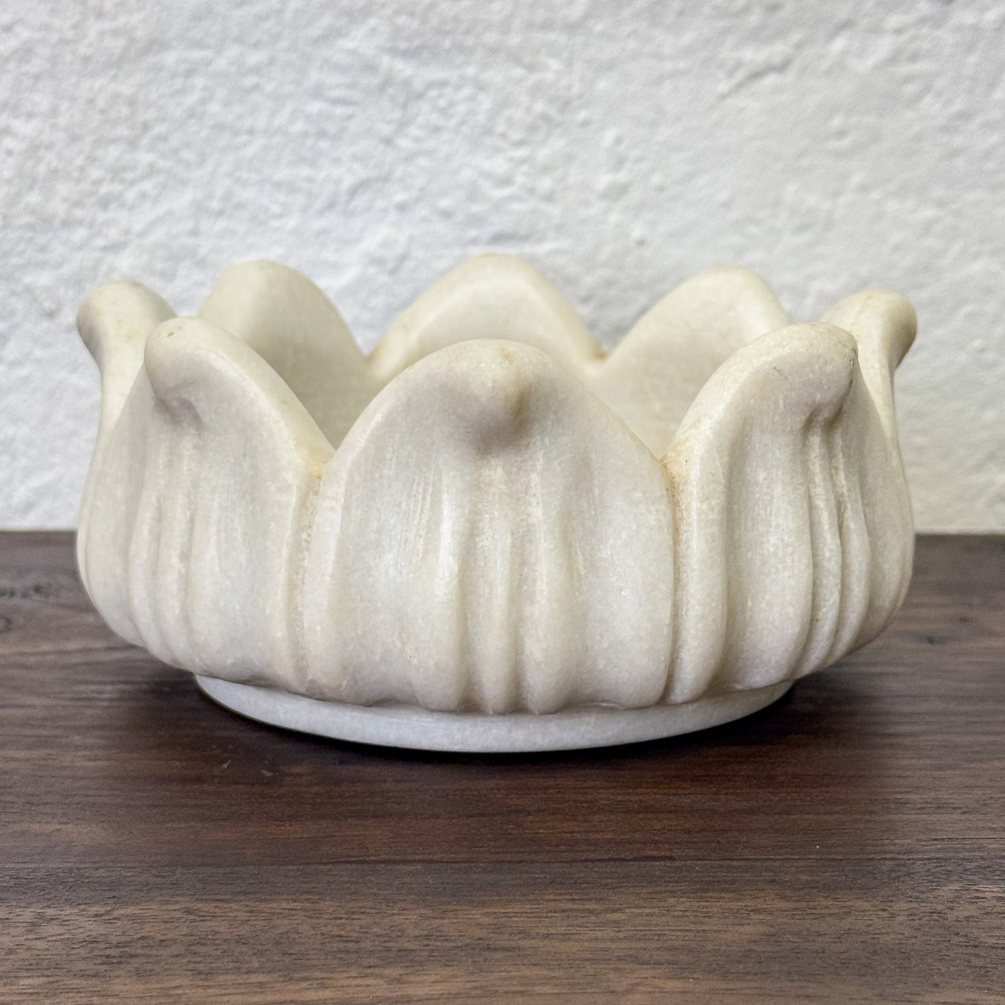 White ceramic bowl with wavy design on a wooden surface