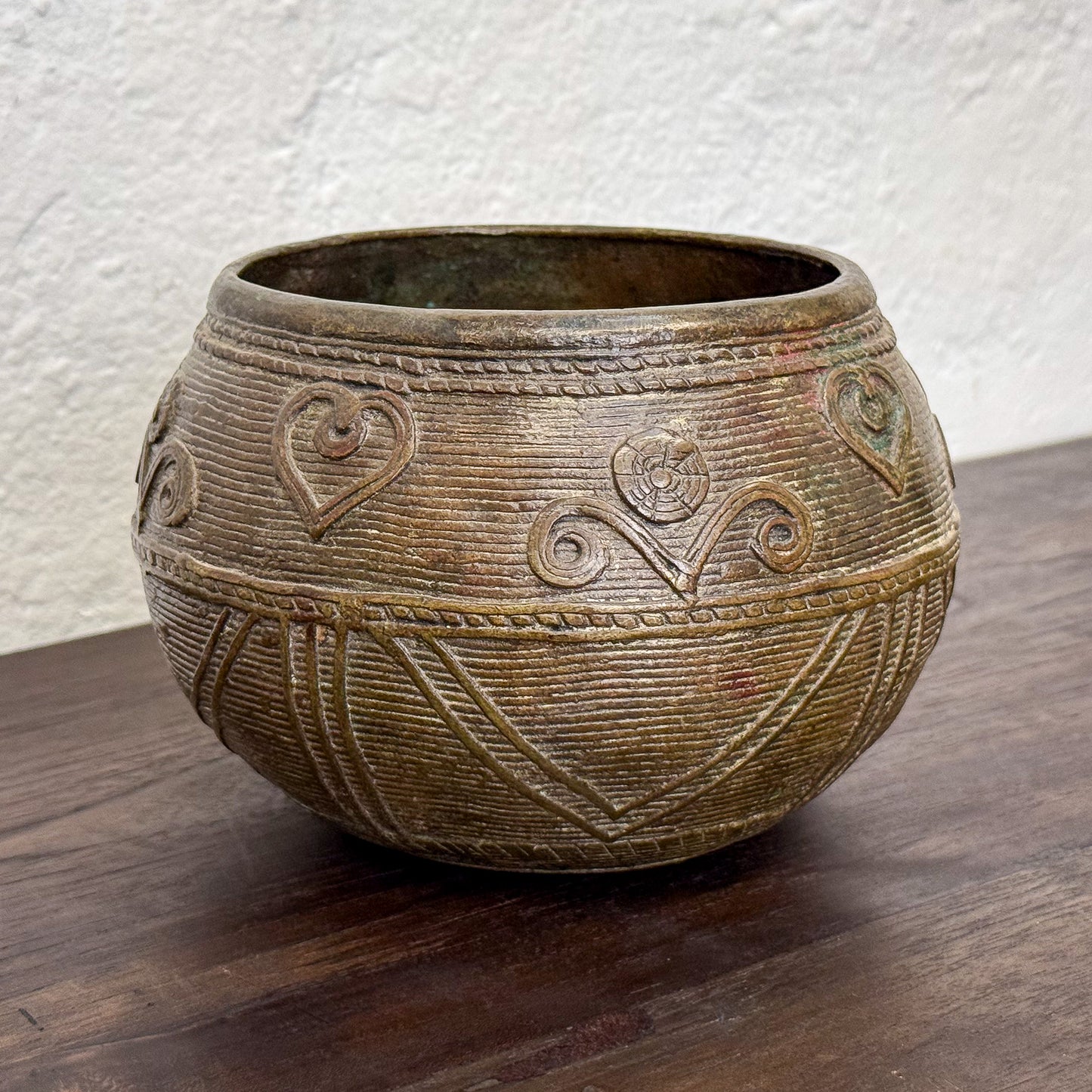 Decorative ceramic pot with heart designs on a wooden surface