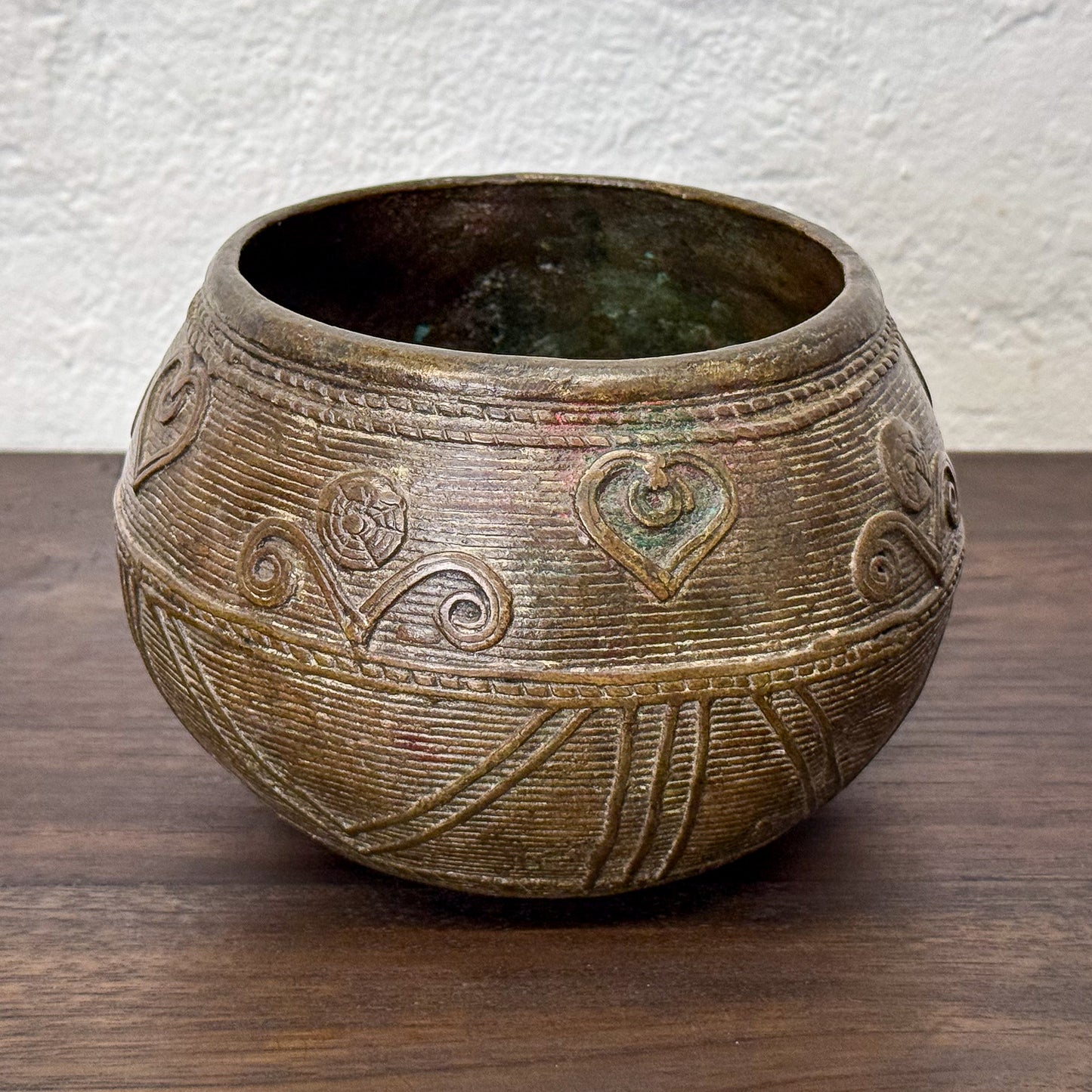 Decorative ceramic bowl with embossed patterns on a wooden surface