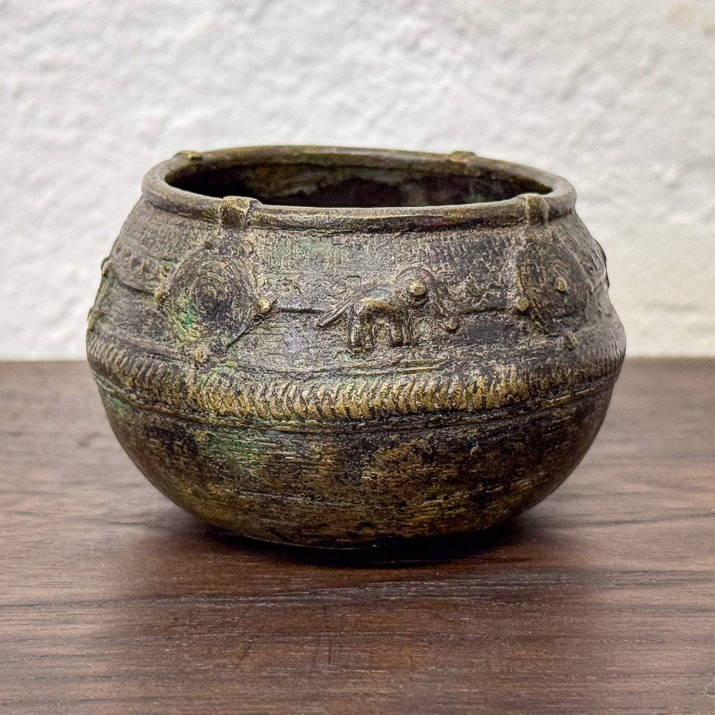 Vintage ceramic pot with decorative patterns on a wooden surface
