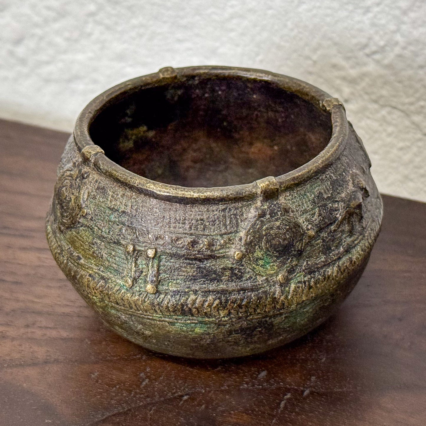 Vintage ceramic pot with decorative patterns on a wooden surface
