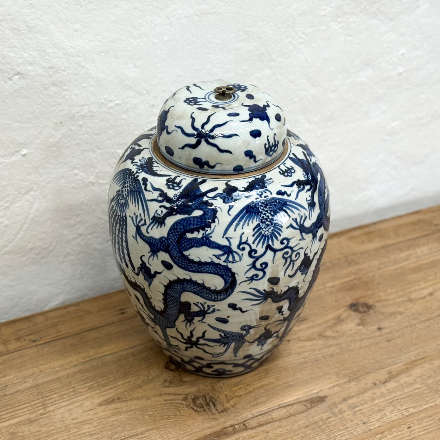 Ceramic jar with blue dragon design on a wooden surface