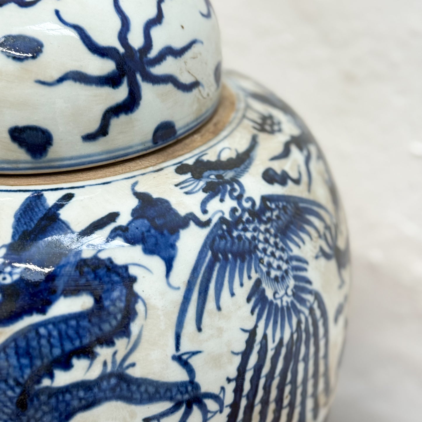 Ceramic jar with blue dragon and phoenix design on a white background