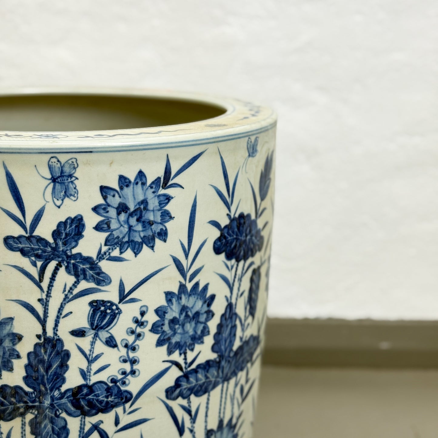 Ceramic pot with blue floral and butterfly design on a white background
