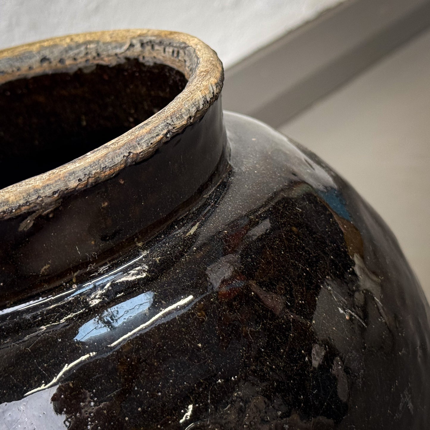 Close-up of a black ceramic vase with a glossy finish