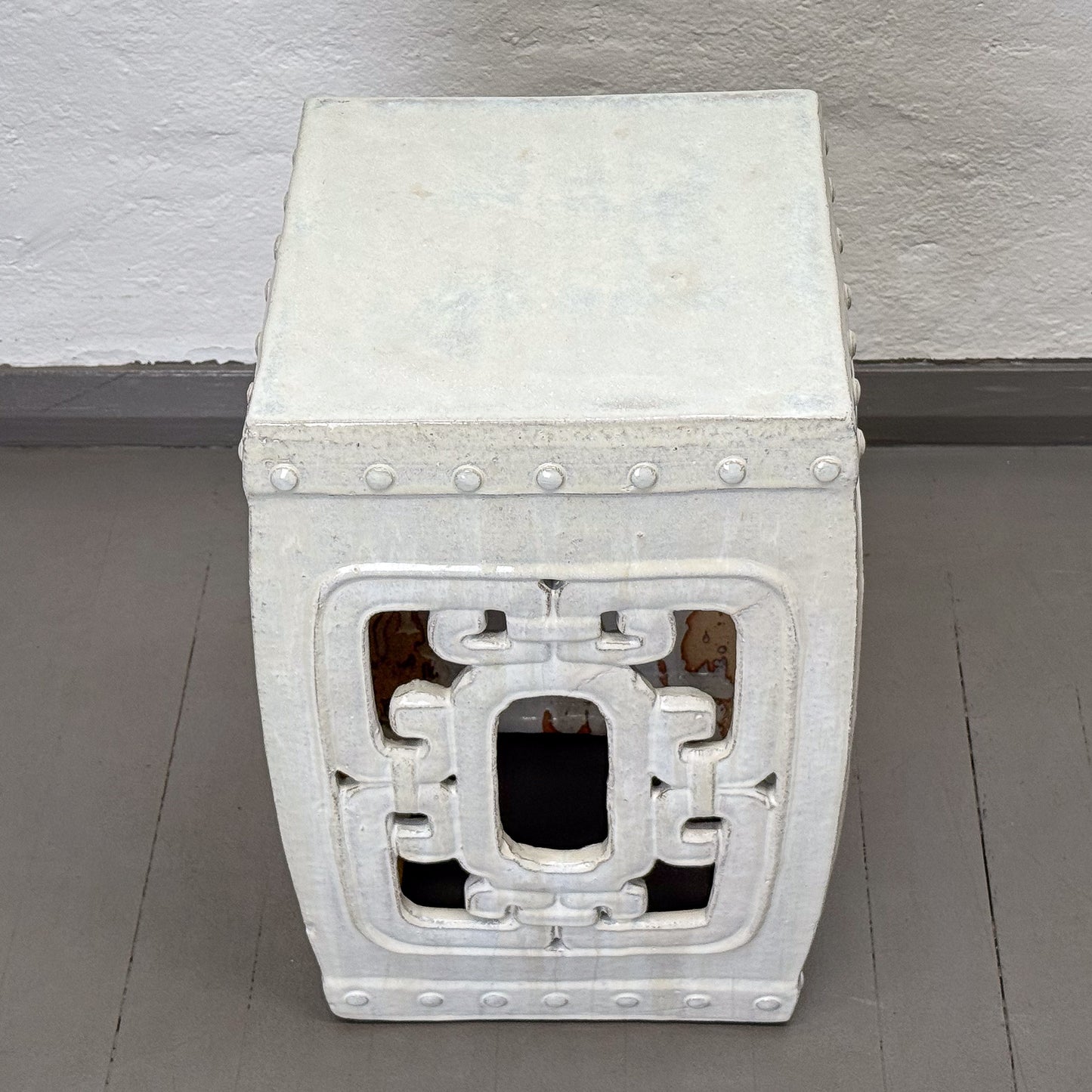 Decorative stone bench with intricate carvings on a gray floor.