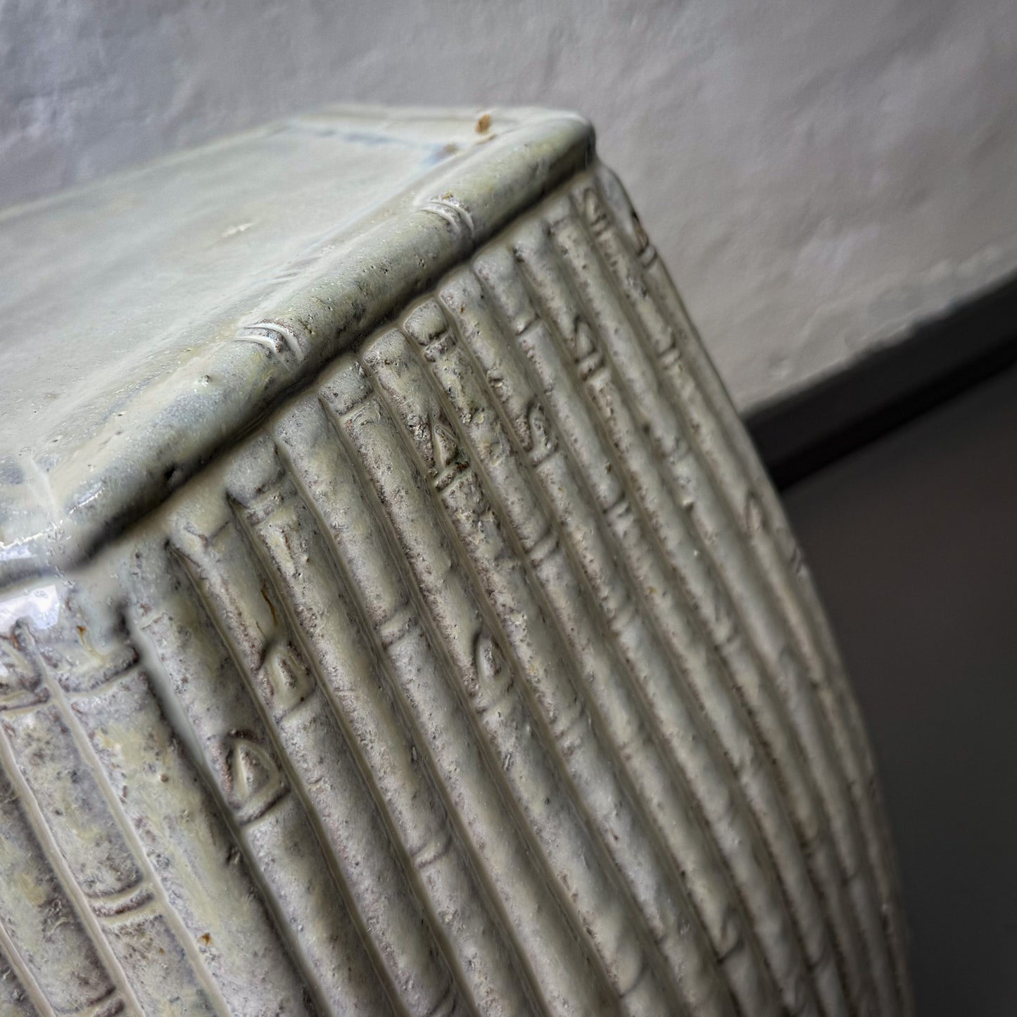 Close-up of a textured ceramic vase with a neutral background