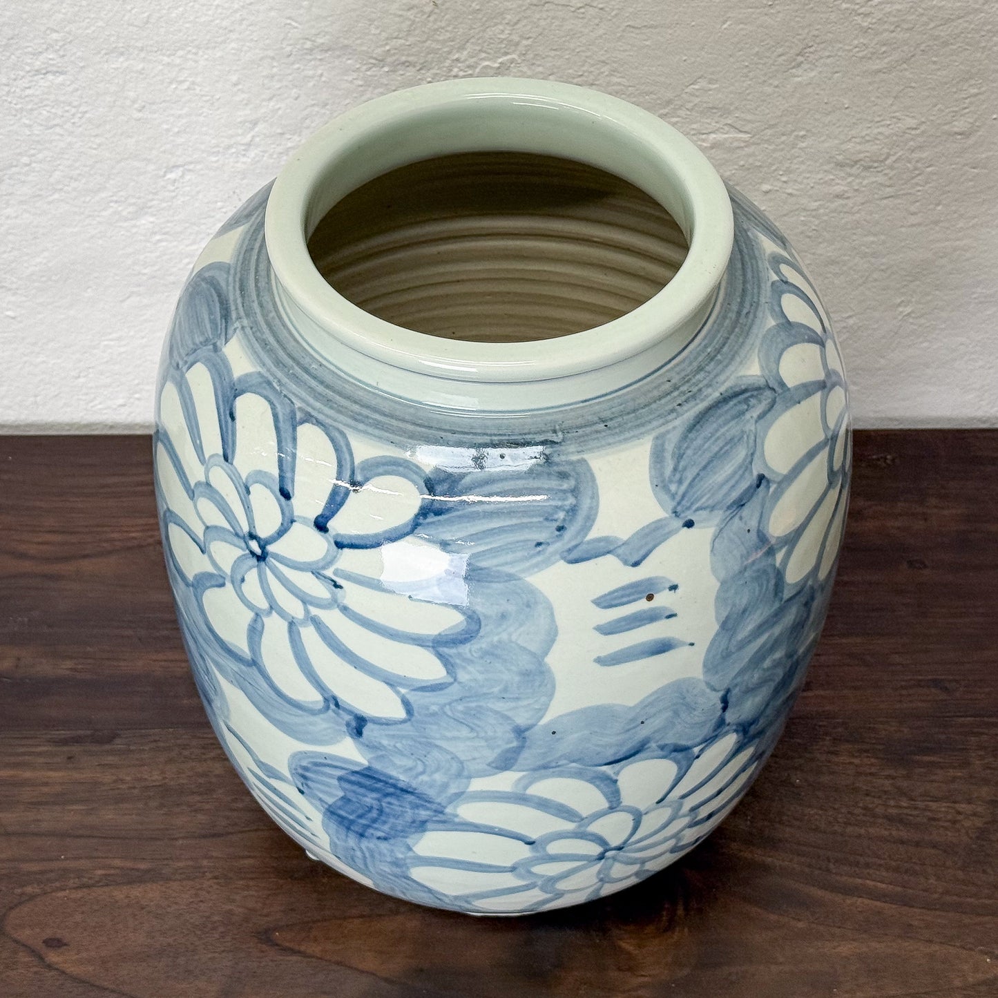 Ceramic jar with blue floral patterns on a wooden surface