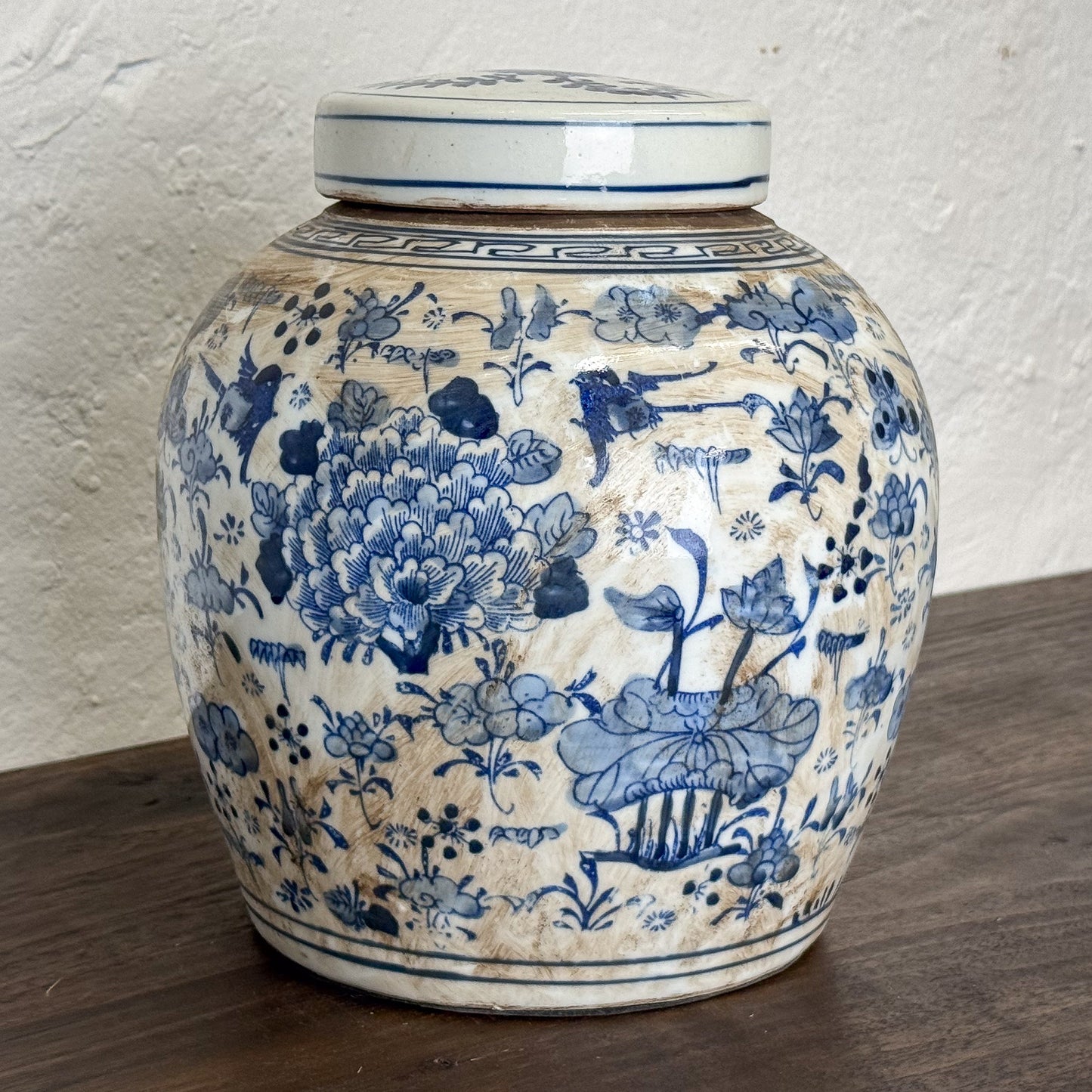 Ceramic jar with blue floral patterns on a wooden surface