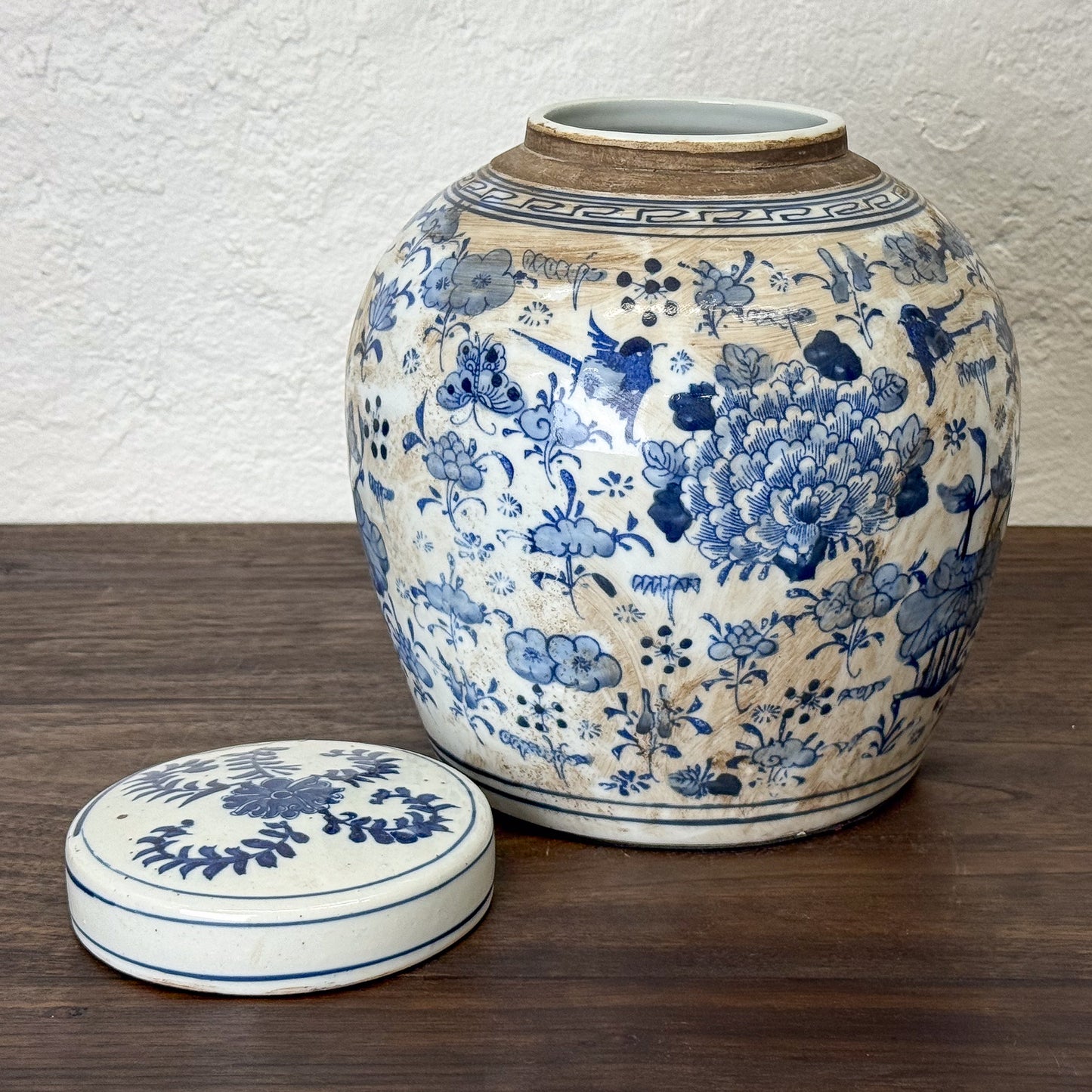 Ceramic jar with blue floral patterns on a wooden surface