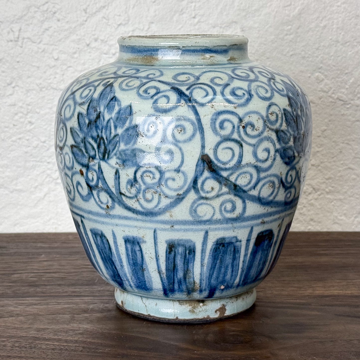 Blue and white ceramic jar with intricate patterns on a wooden surface.
