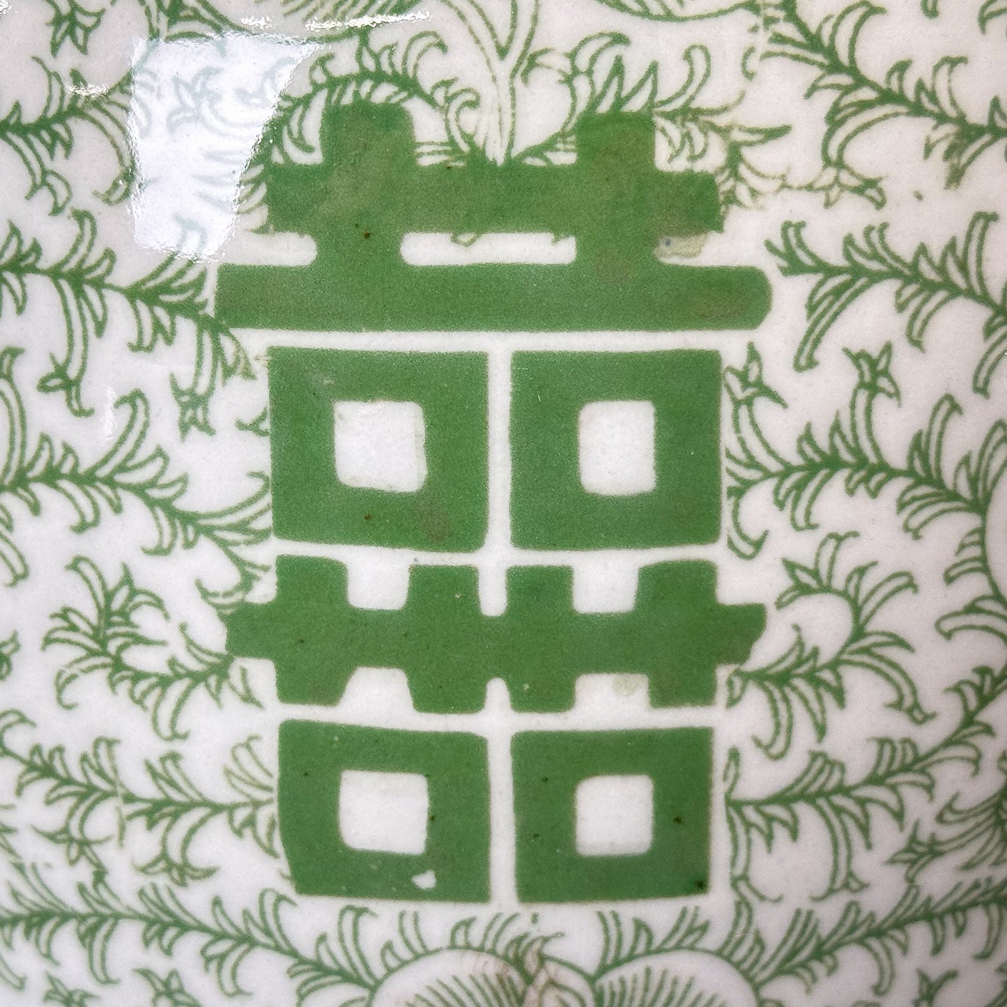 Green double happiness symbol on a white background with floral patterns