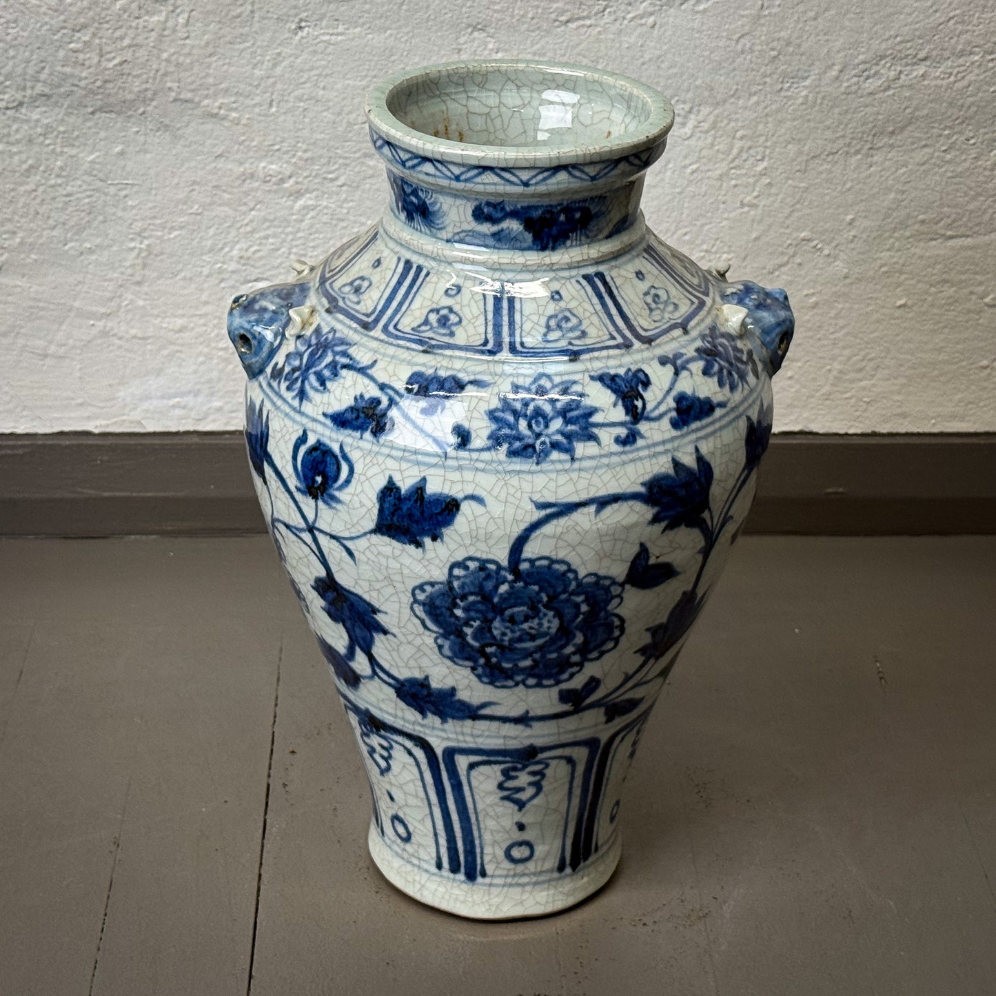 Blue and white ceramic vase with floral patterns on a plain background