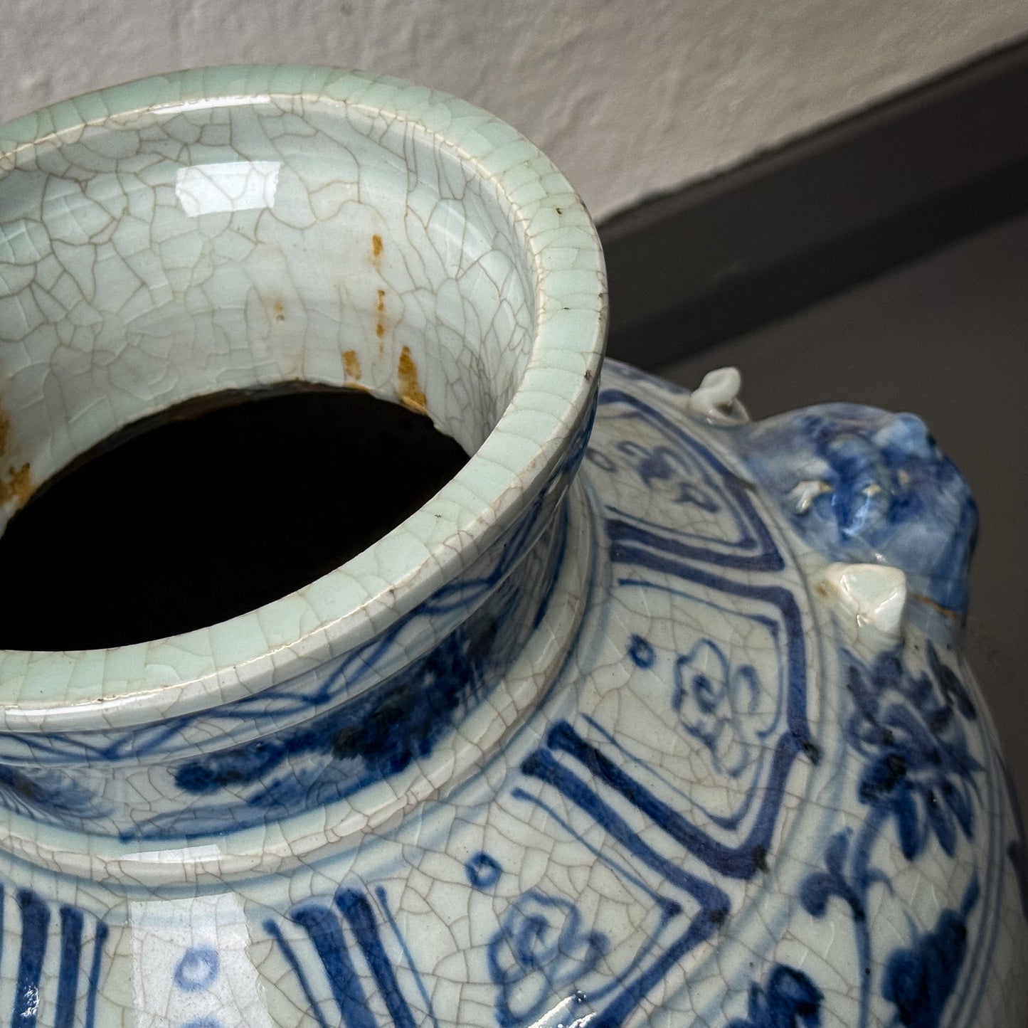 Close-up of a ceramic vase with blue and white patterns on a neutral background