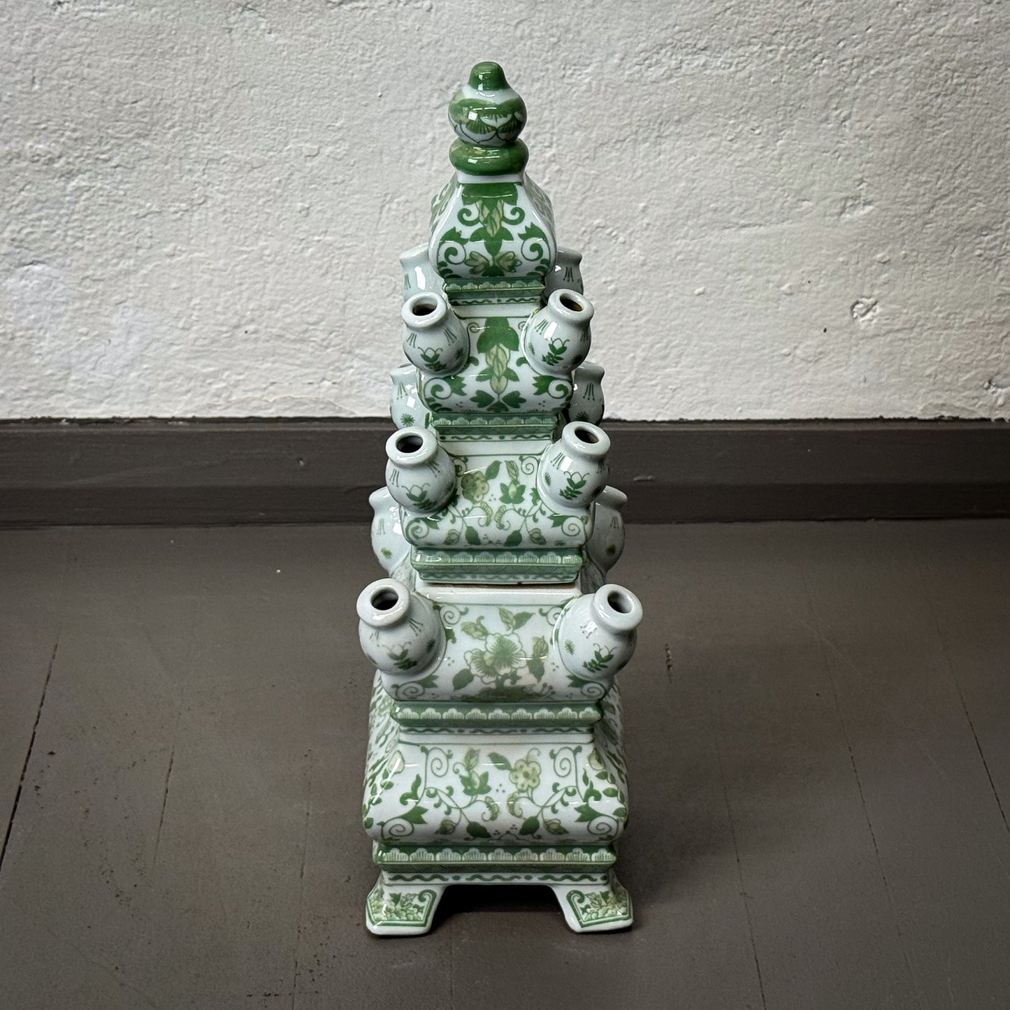 Green ceramic vase tower on a plain background