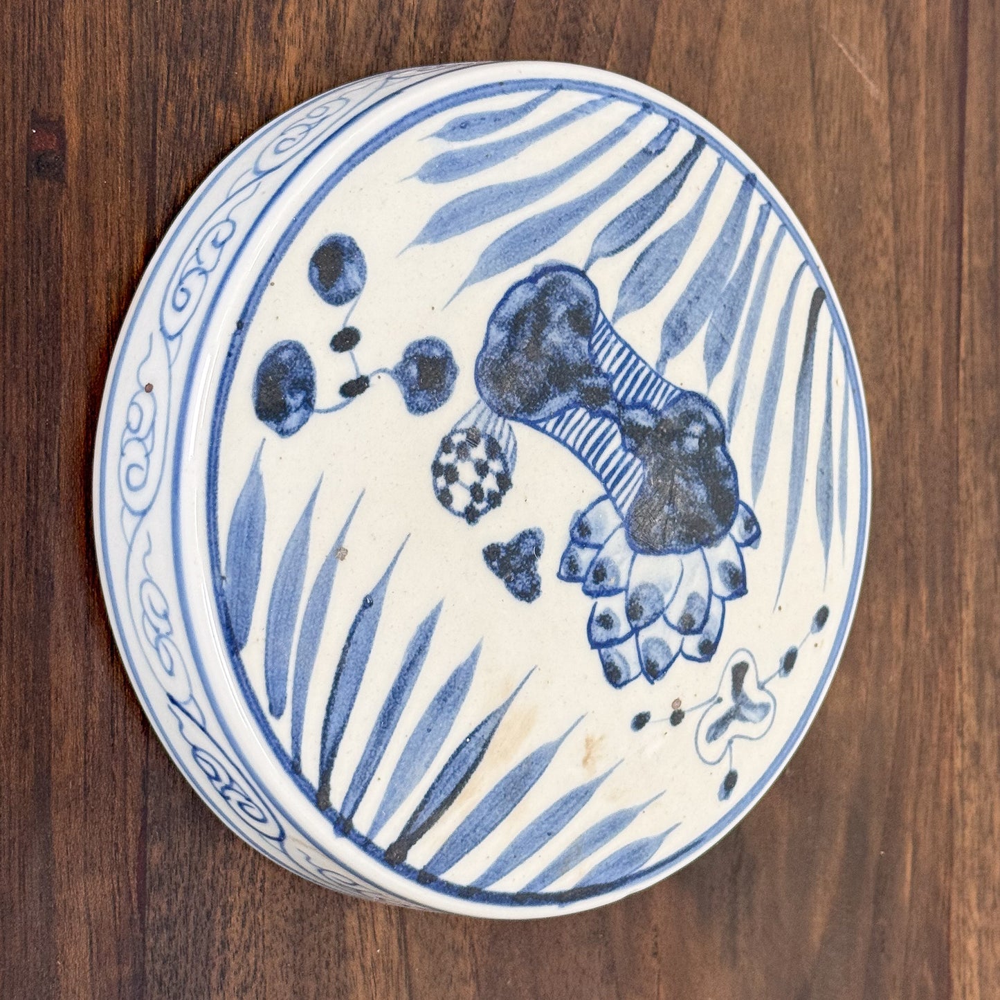 Ceramic plate with blue floral design on a wooden surface