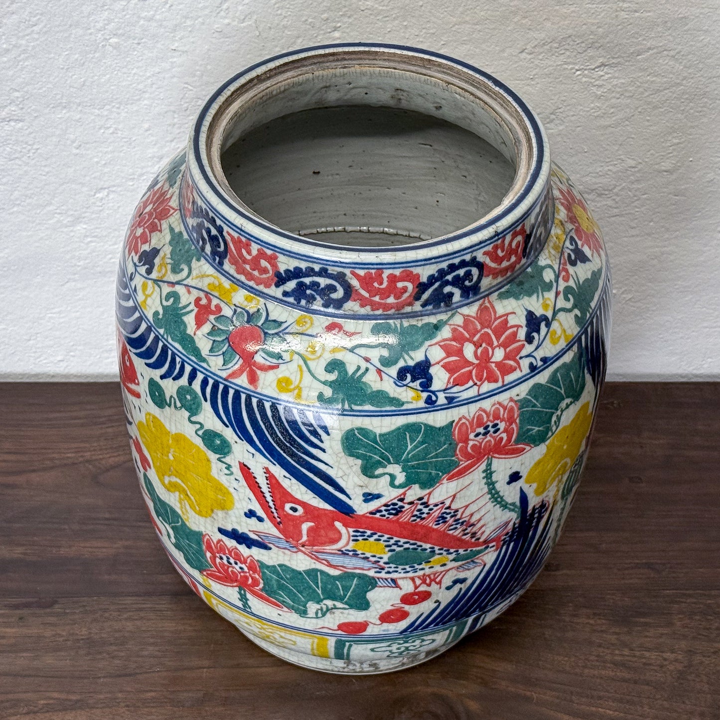 Colorful ceramic jar with intricate patterns on a wooden surface.
