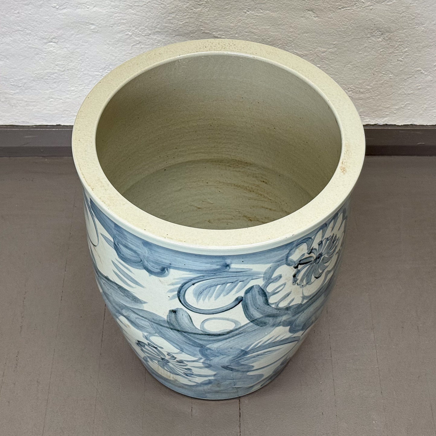 Decorative tile with floral design in blue on a beige background