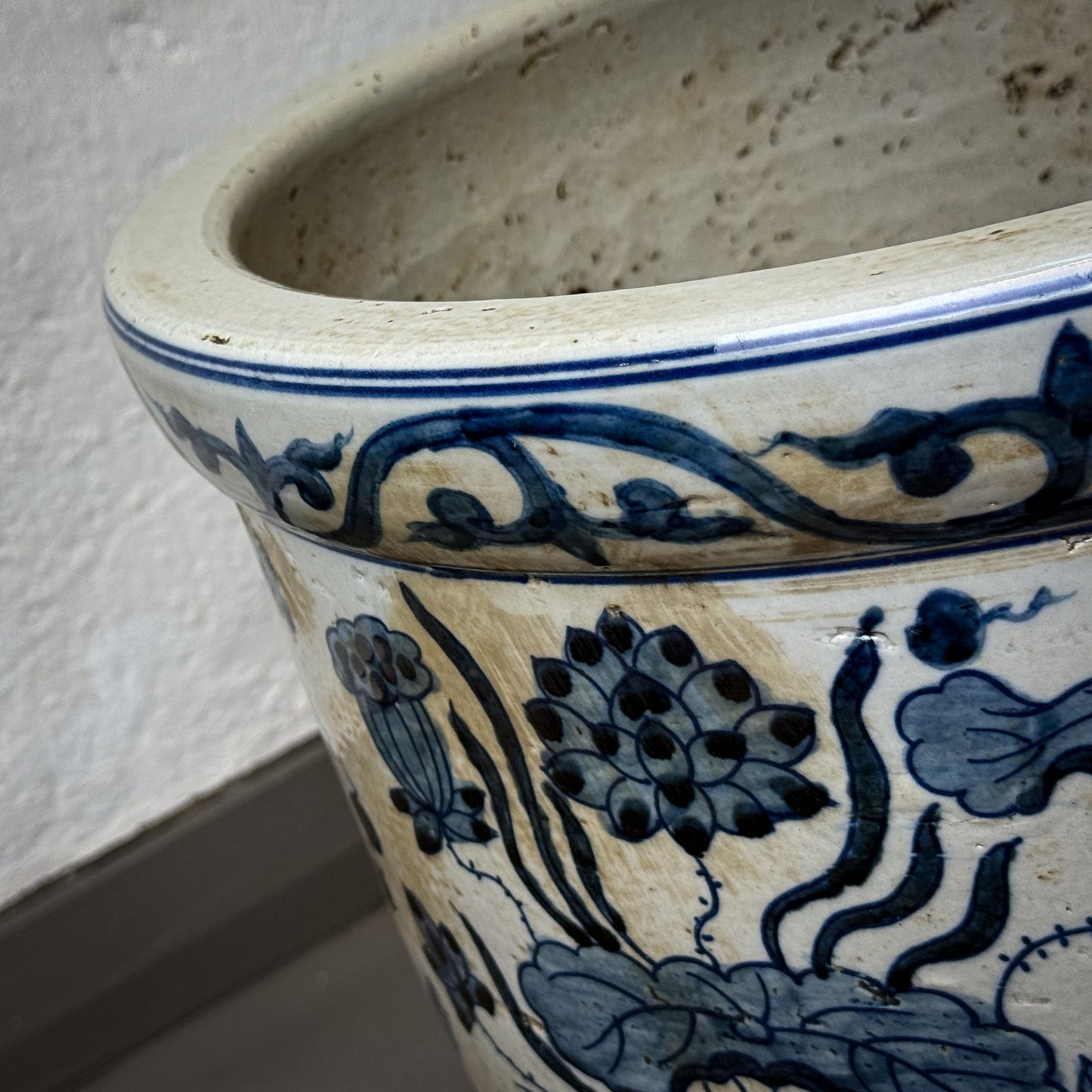 Ceramic pot with blue floral patterns on a neutral background