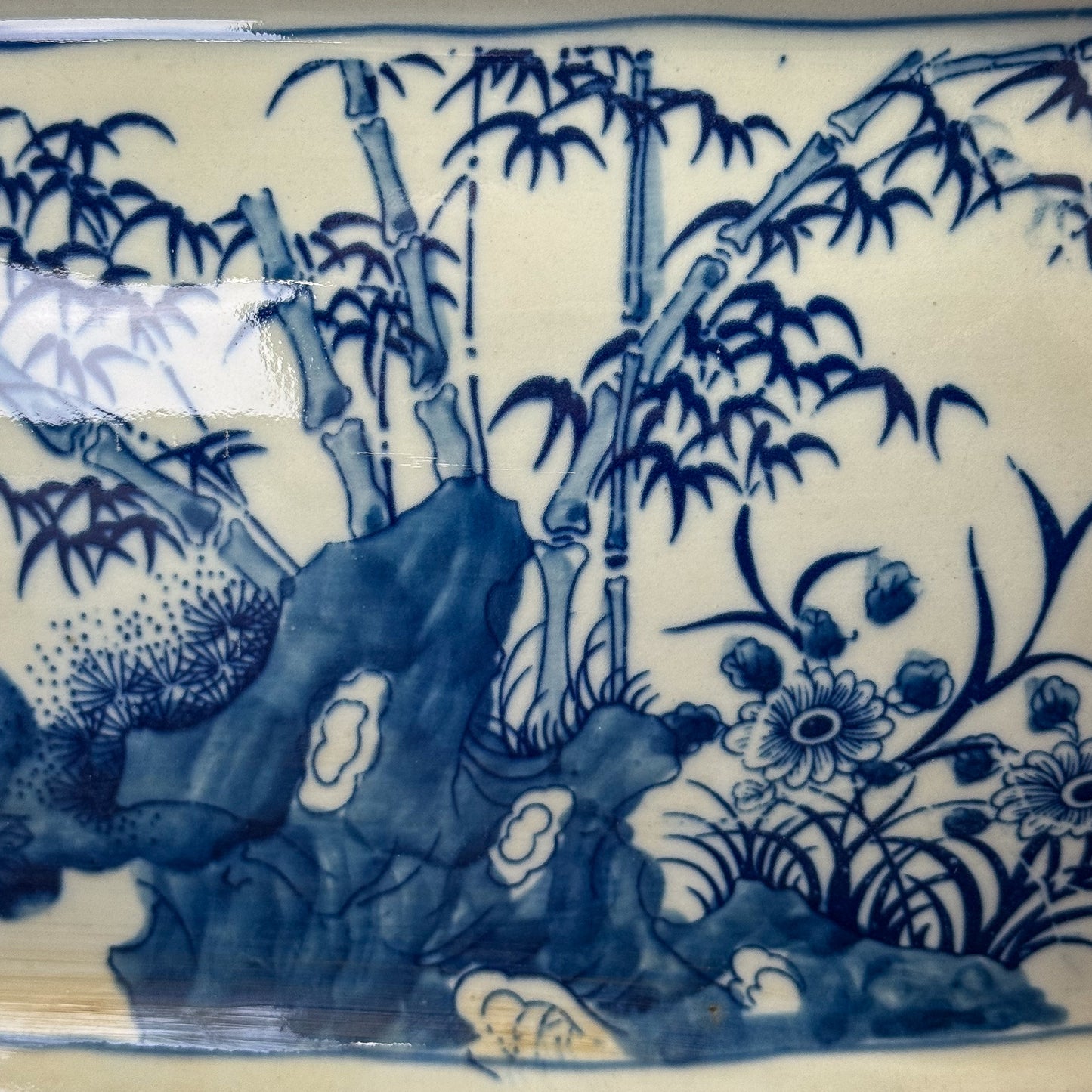 Blue and white ceramic plate with bamboo and rock design