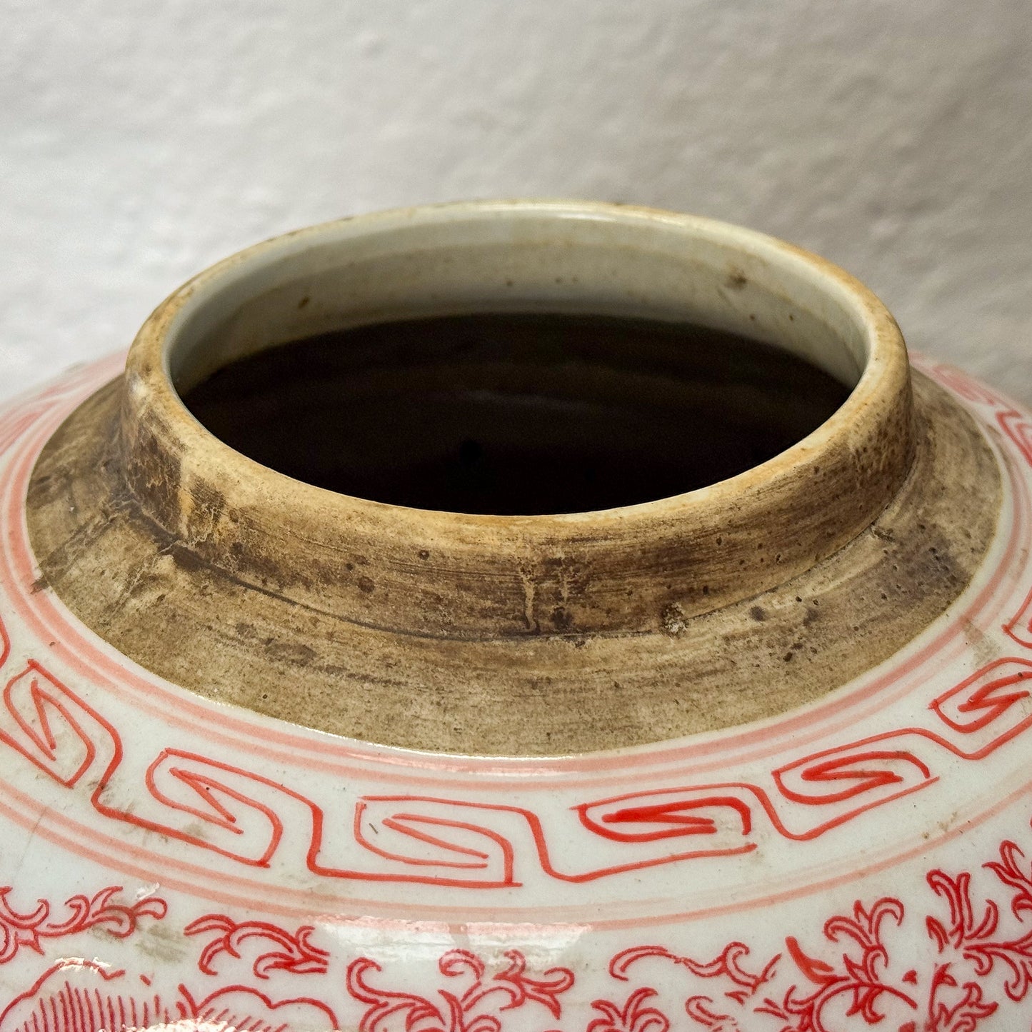 Ceramic jar with red floral patterns on a white background