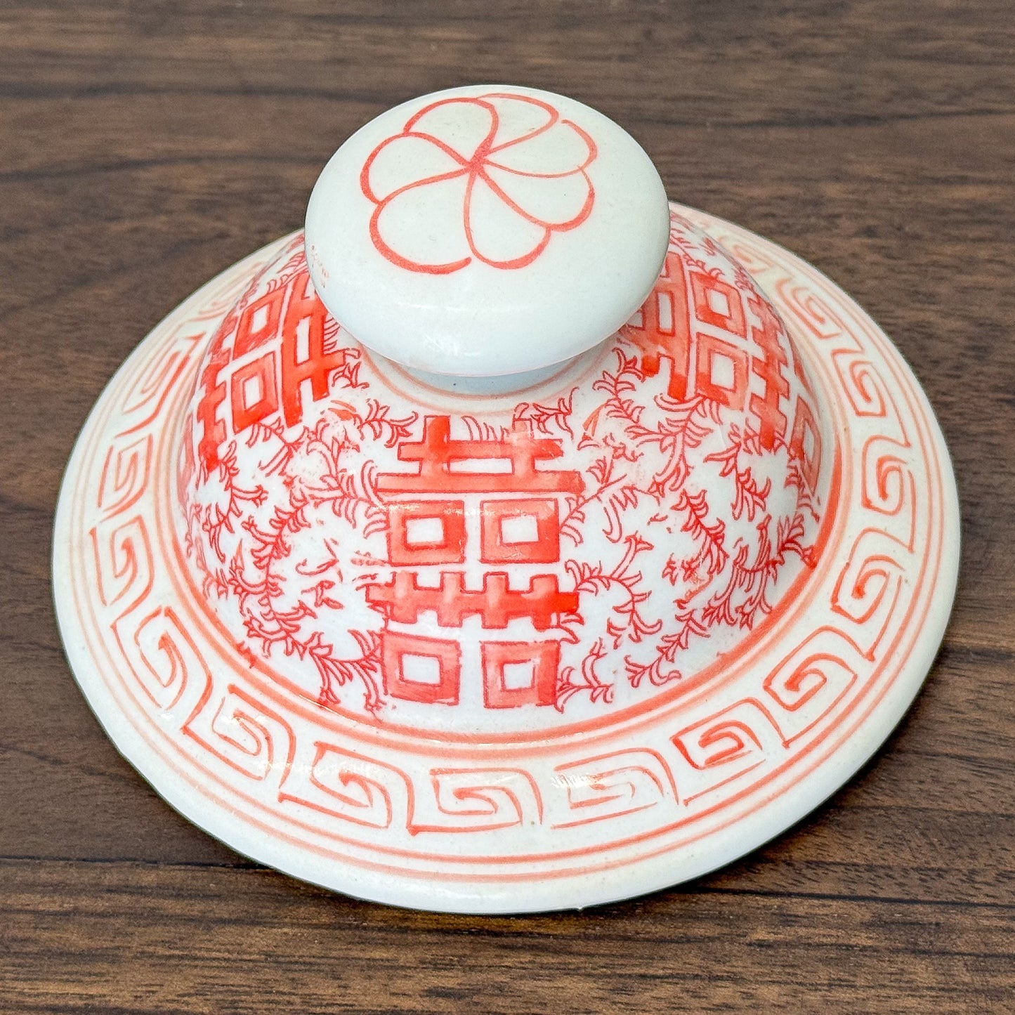 Ceramic jar with red floral patterns on a white background