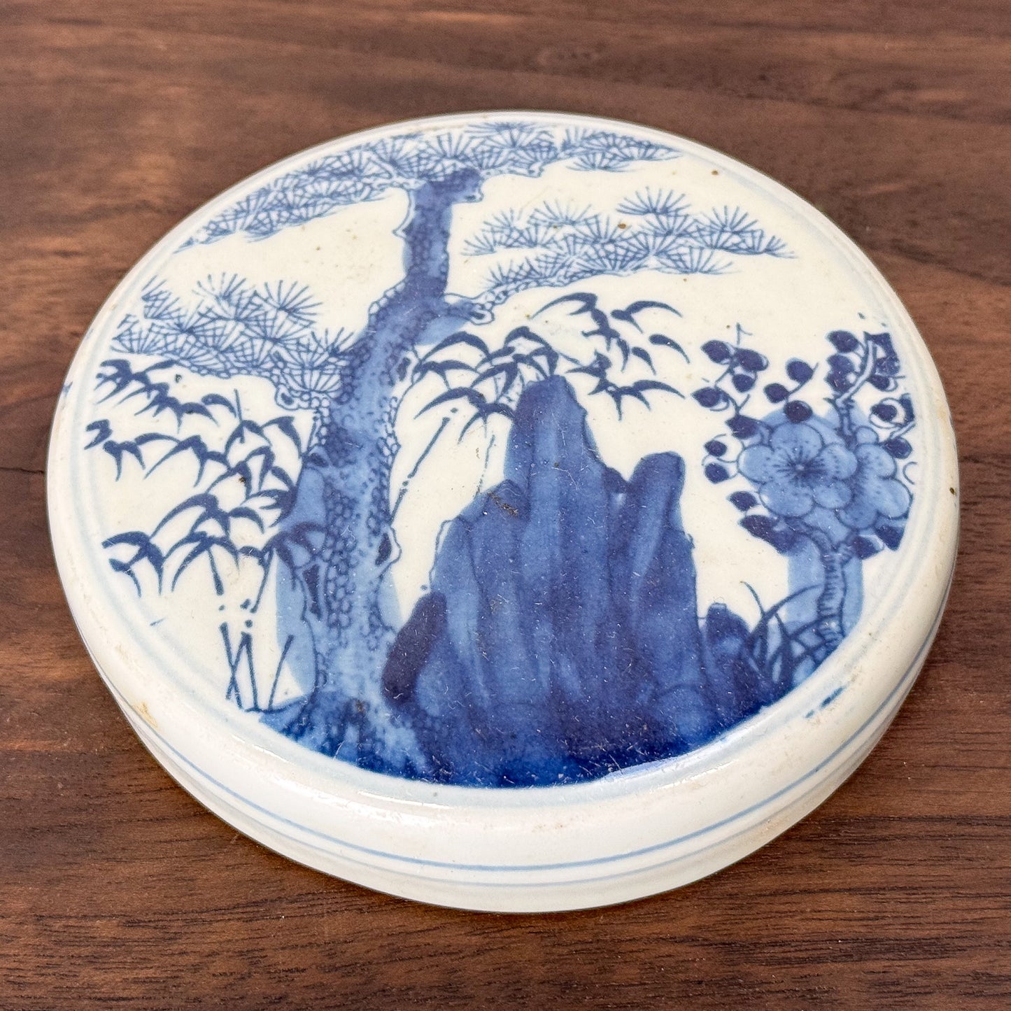 Blue and white ceramic plate with nature design on a wooden surface