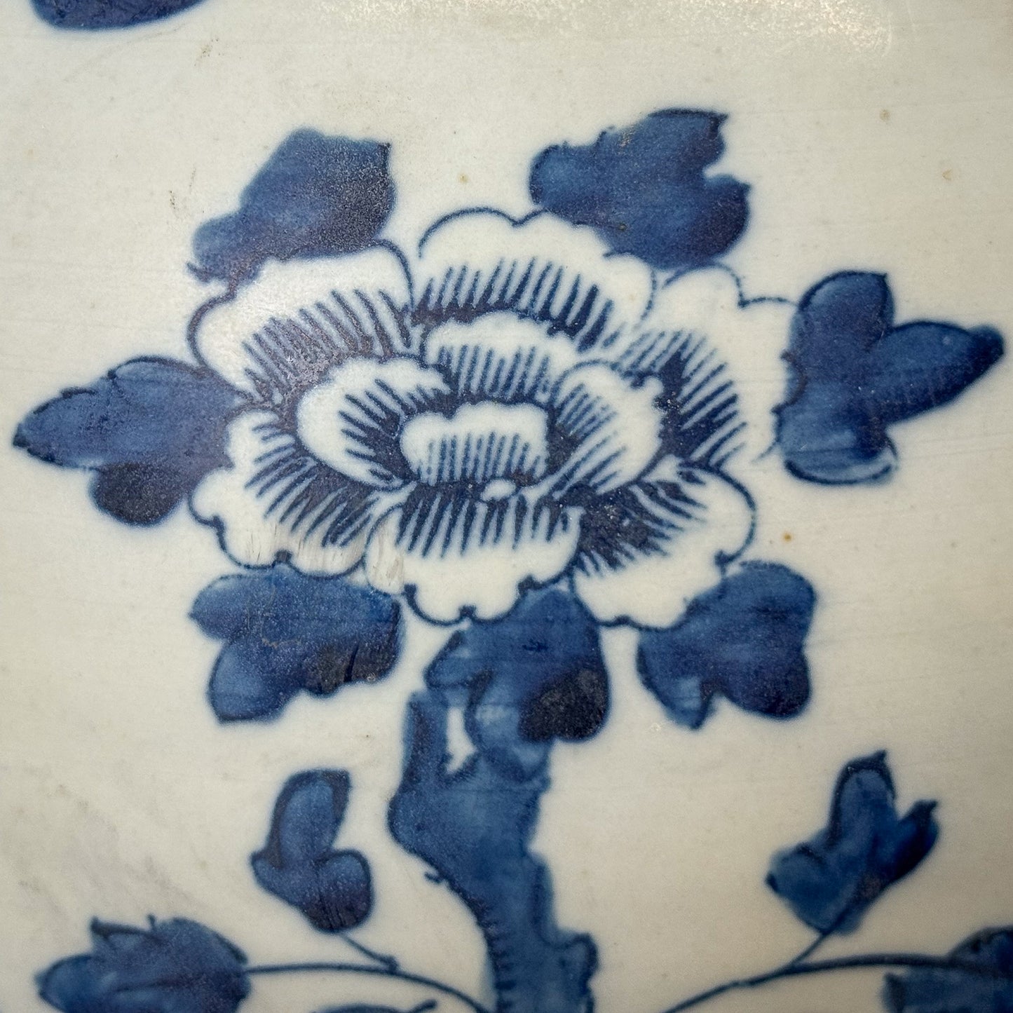 Blue floral design on a white ceramic tile