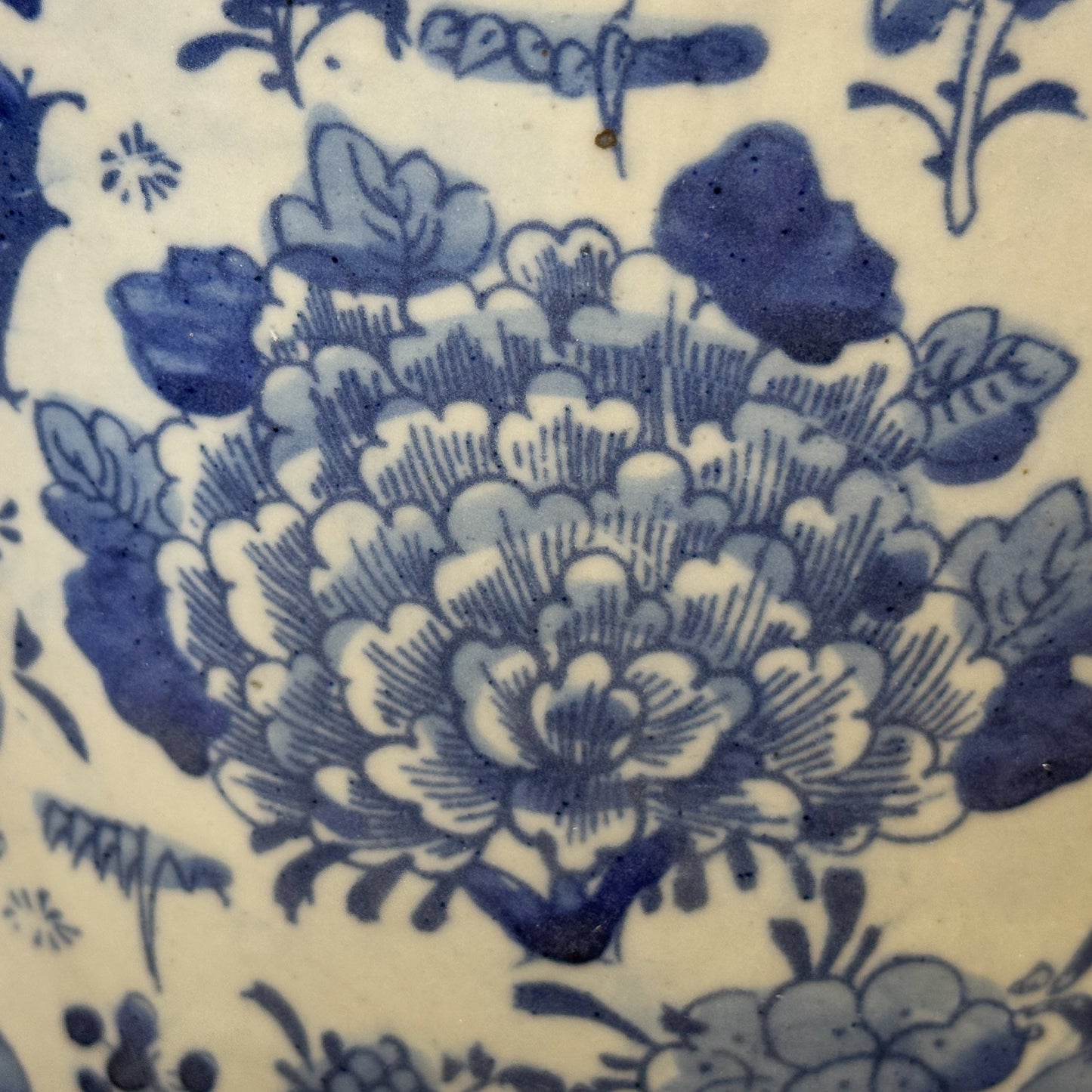 Close-up of blue floral pattern on white ceramic surface