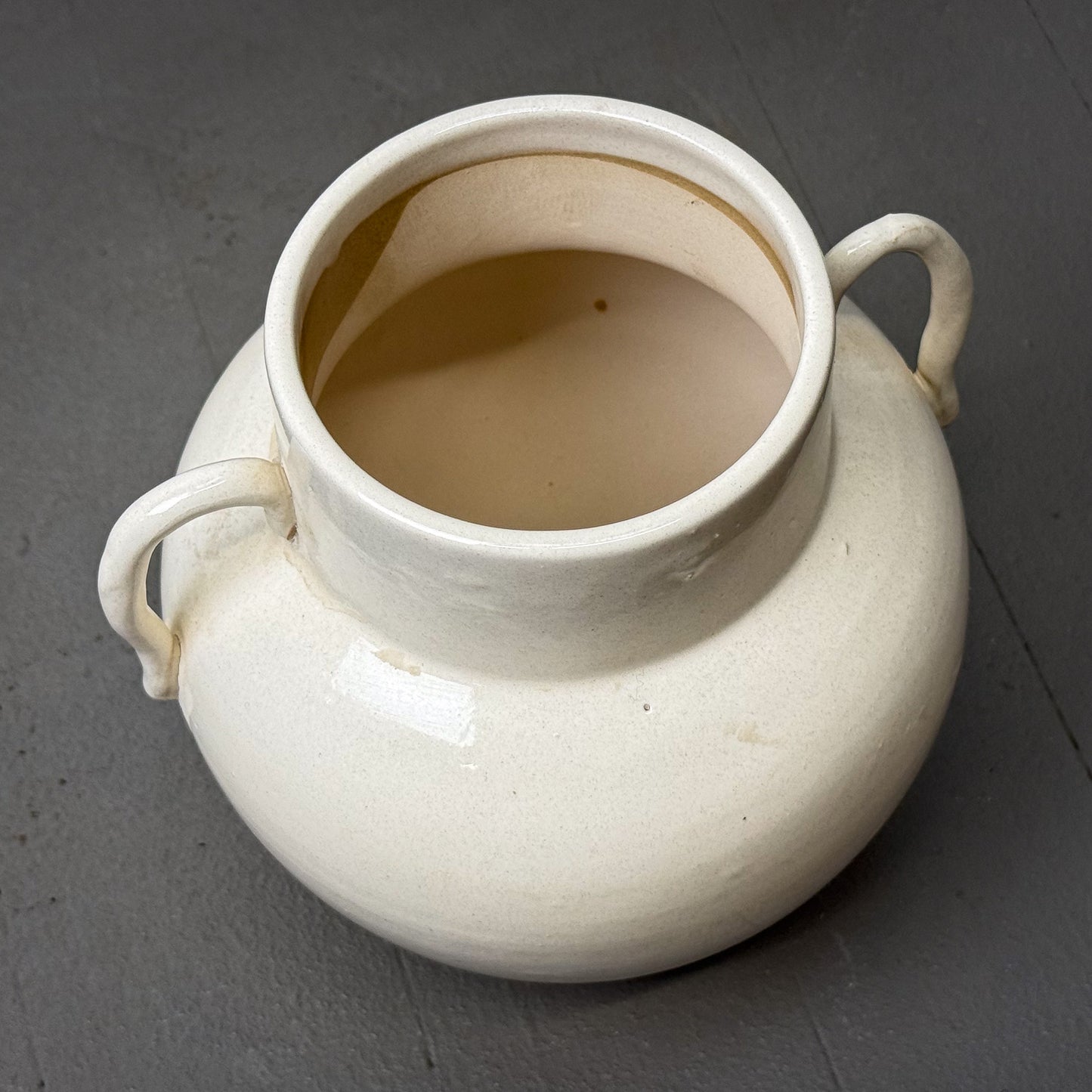 White ceramic pitcher with handles on a gray background