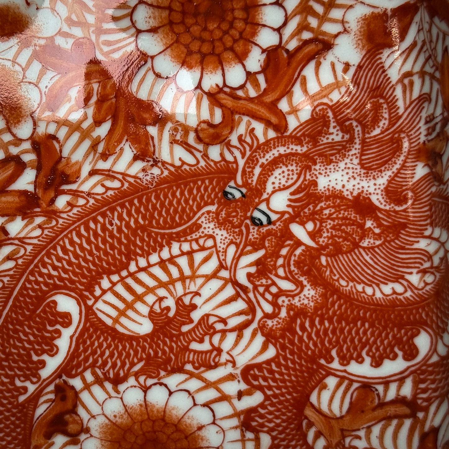 Decorative pattern with dragons and floral elements in brown on a white background