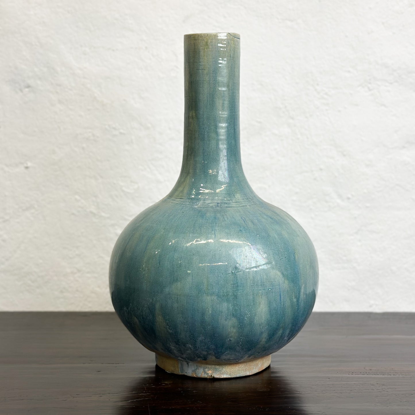 A ceramic globular vase with a blue-green glaze, displayed against a neutral background.