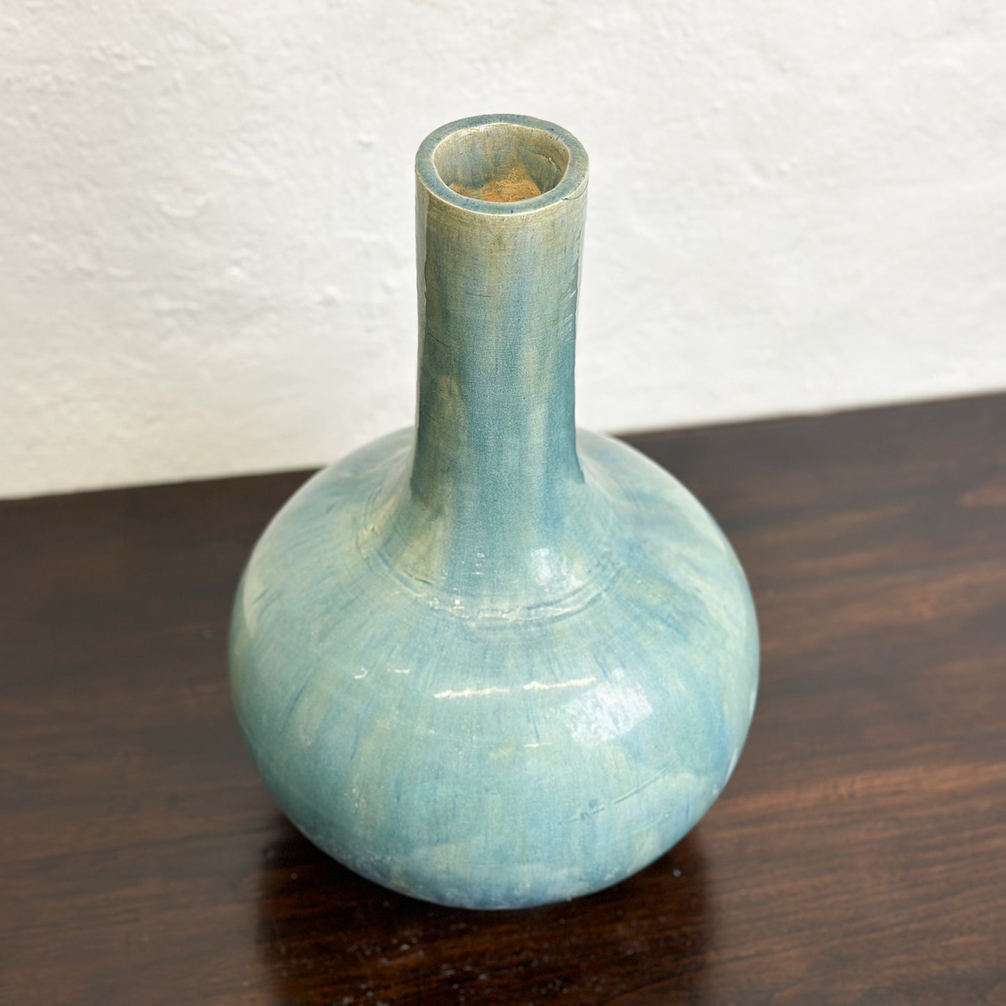 A ceramic globular vase with a blue-green glaze, displayed against a neutral background.
