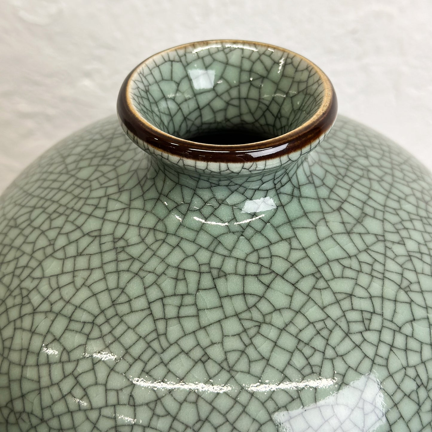 A Crackled Celadon Meiping Vase with a greenish color and a craquelure effect, displayed against a neutral background.