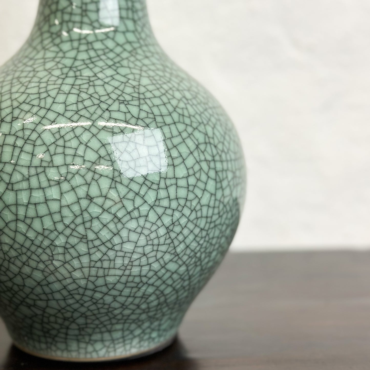 A crackled celadon globular vase with flared lip, displayed against a neutral background.