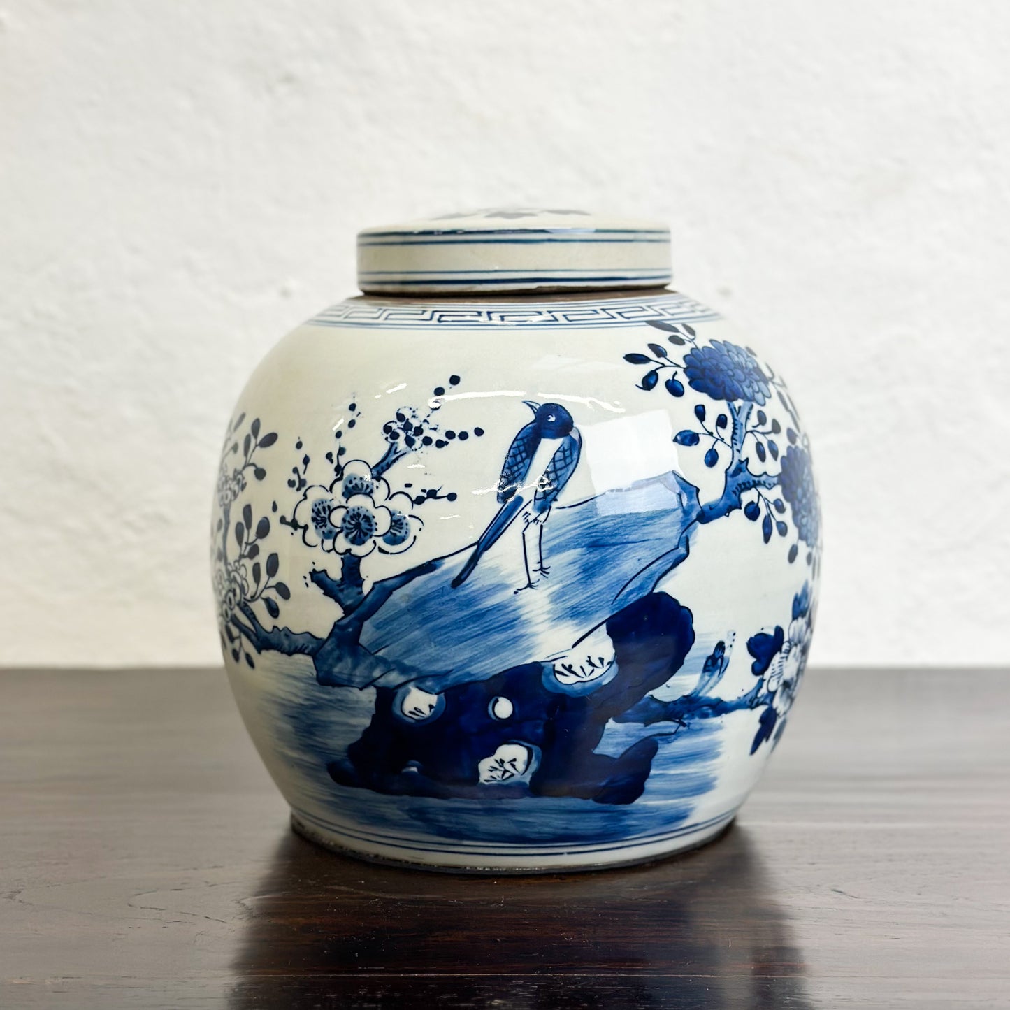A porcelain ginger jar with blue and white floral patterns and a bird design.