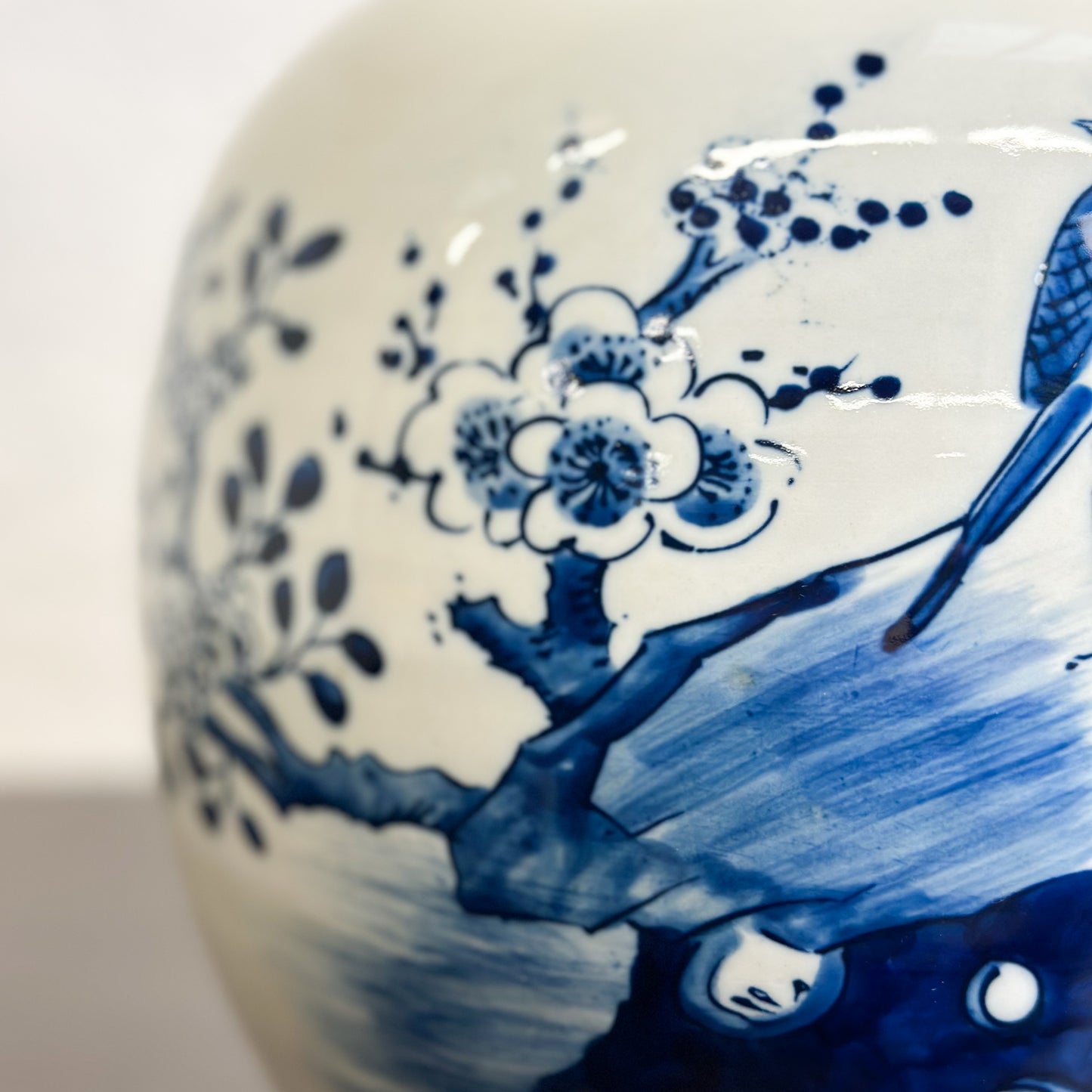 A porcelain ginger jar with blue and white floral patterns and a bird design.