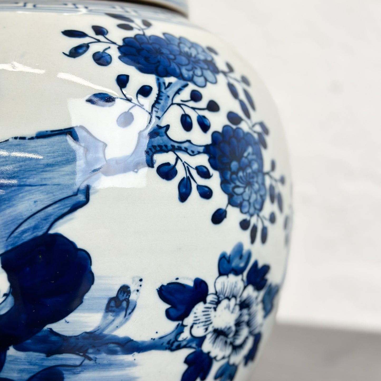 A porcelain ginger jar with blue and white floral patterns and a bird design.