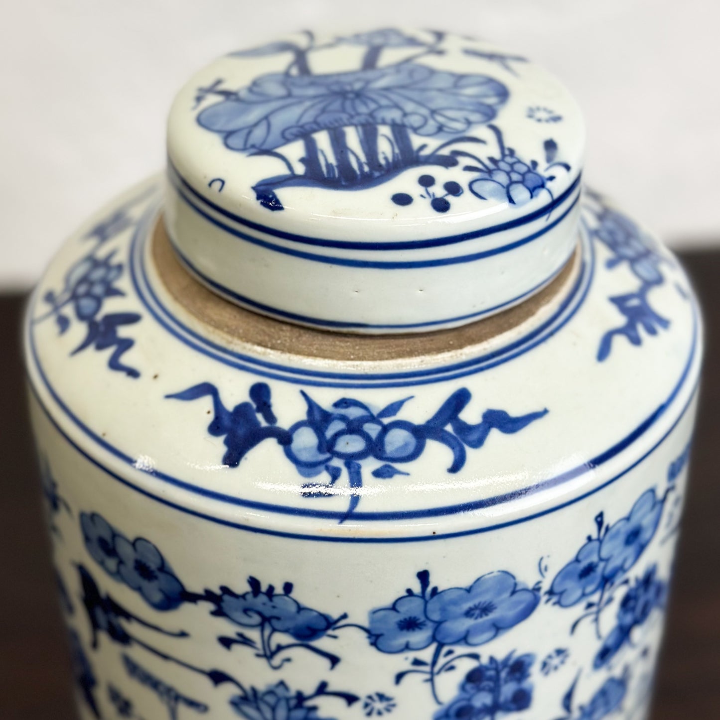 A cylindrical porcelain container with a lid, featuring a hand-painted floral design in blue and white colors.