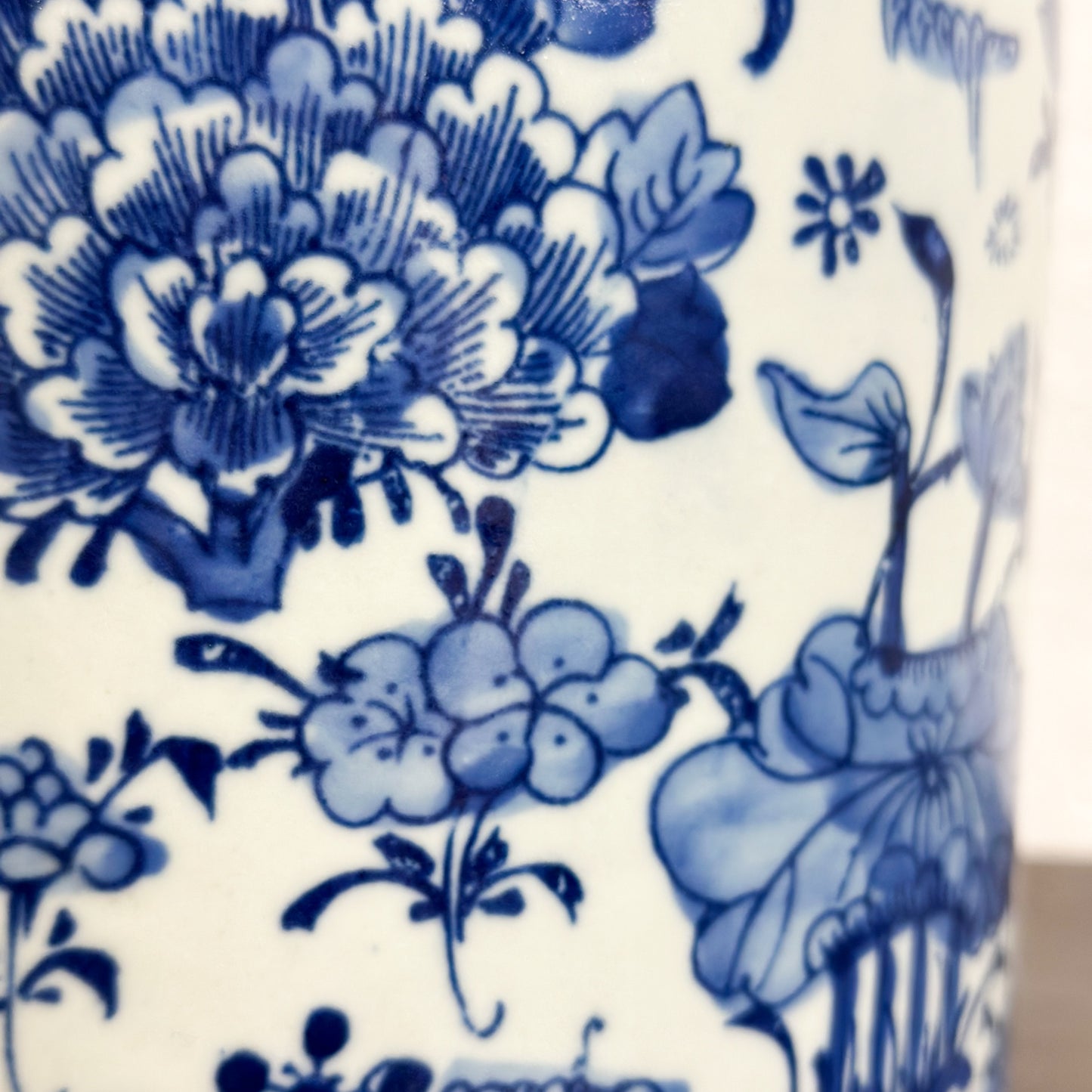 A cylindrical porcelain container with a lid, featuring a hand-painted floral design in blue and white colors.