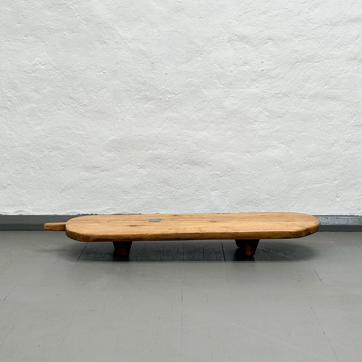 Wooden bench against a plain white wall