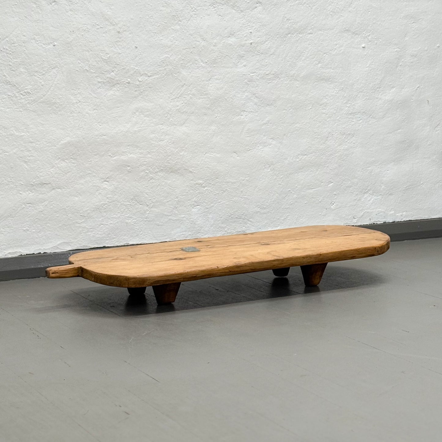 Wooden bench against a plain wall