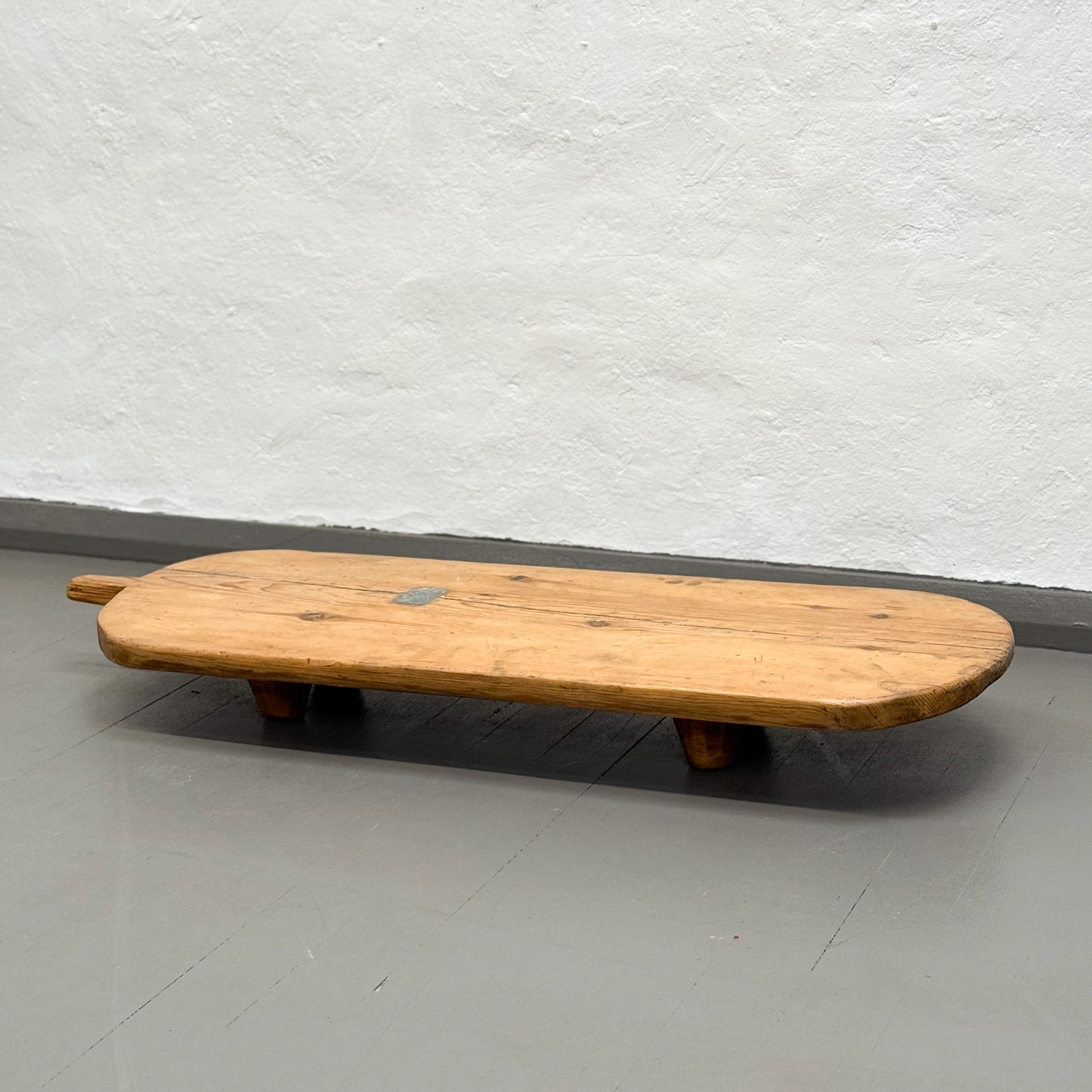 Wooden bench against a white wall