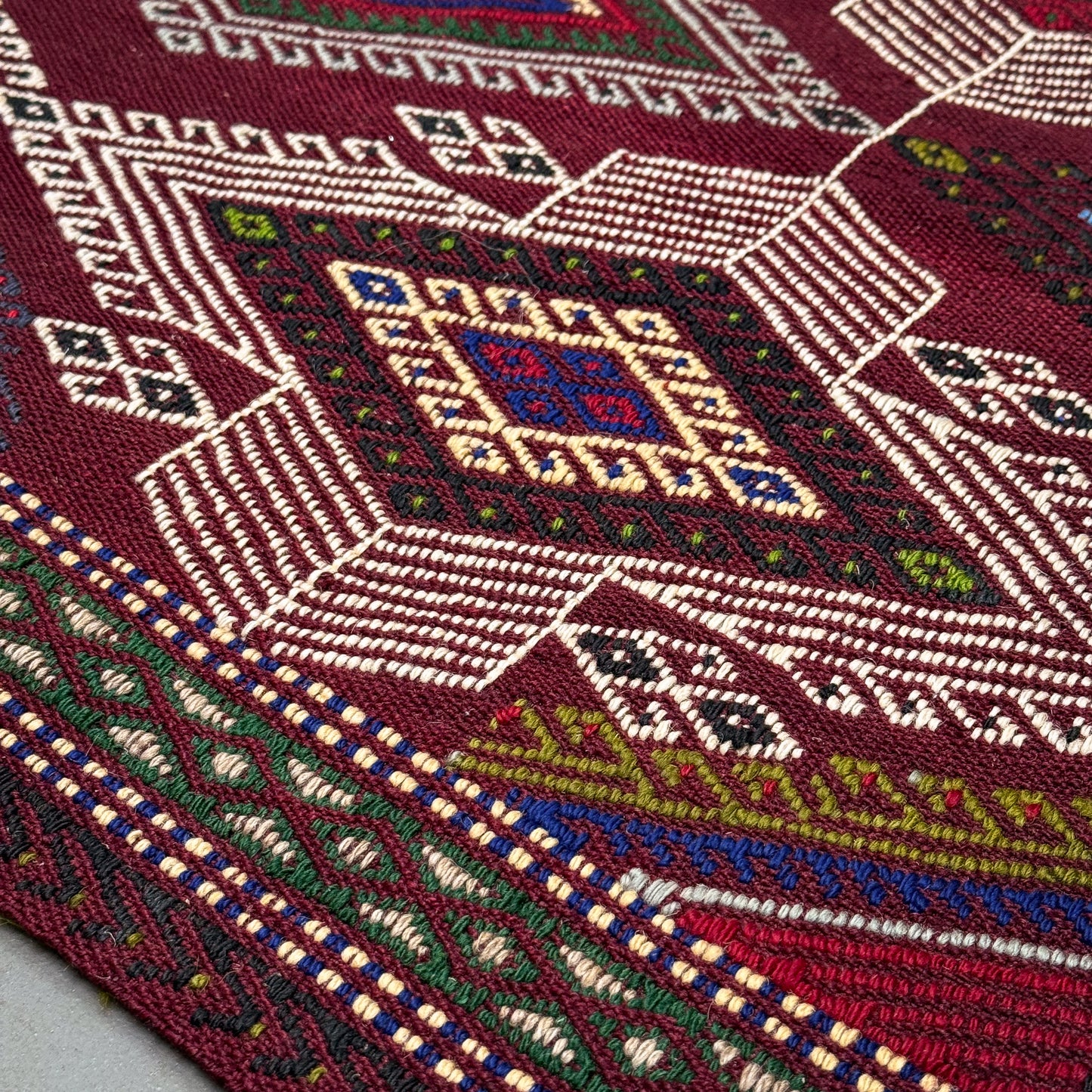 Close-up of a woven textile with intricate patterns and colors.