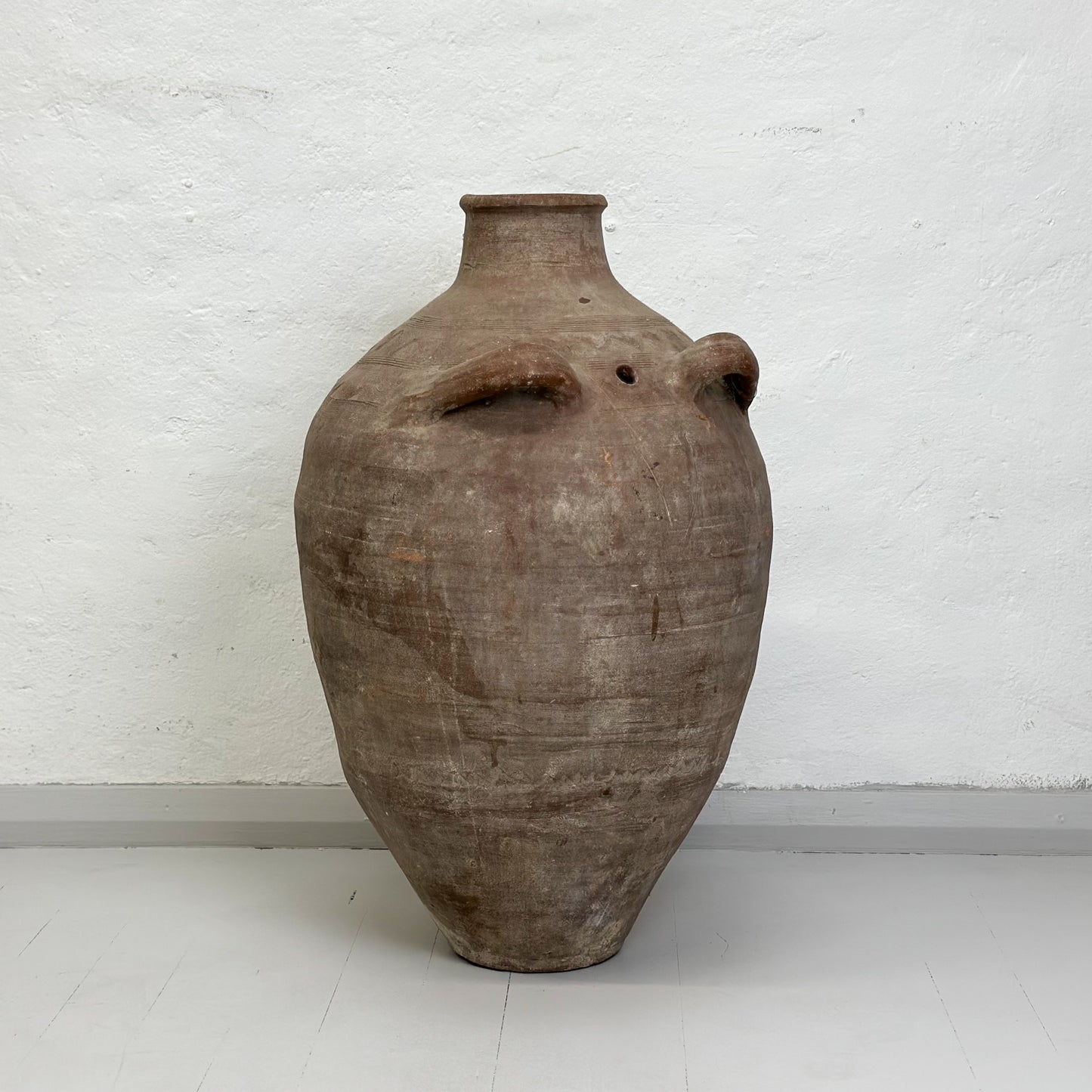A large Turkish milk churn made of earthenware, displayed against a white background.
