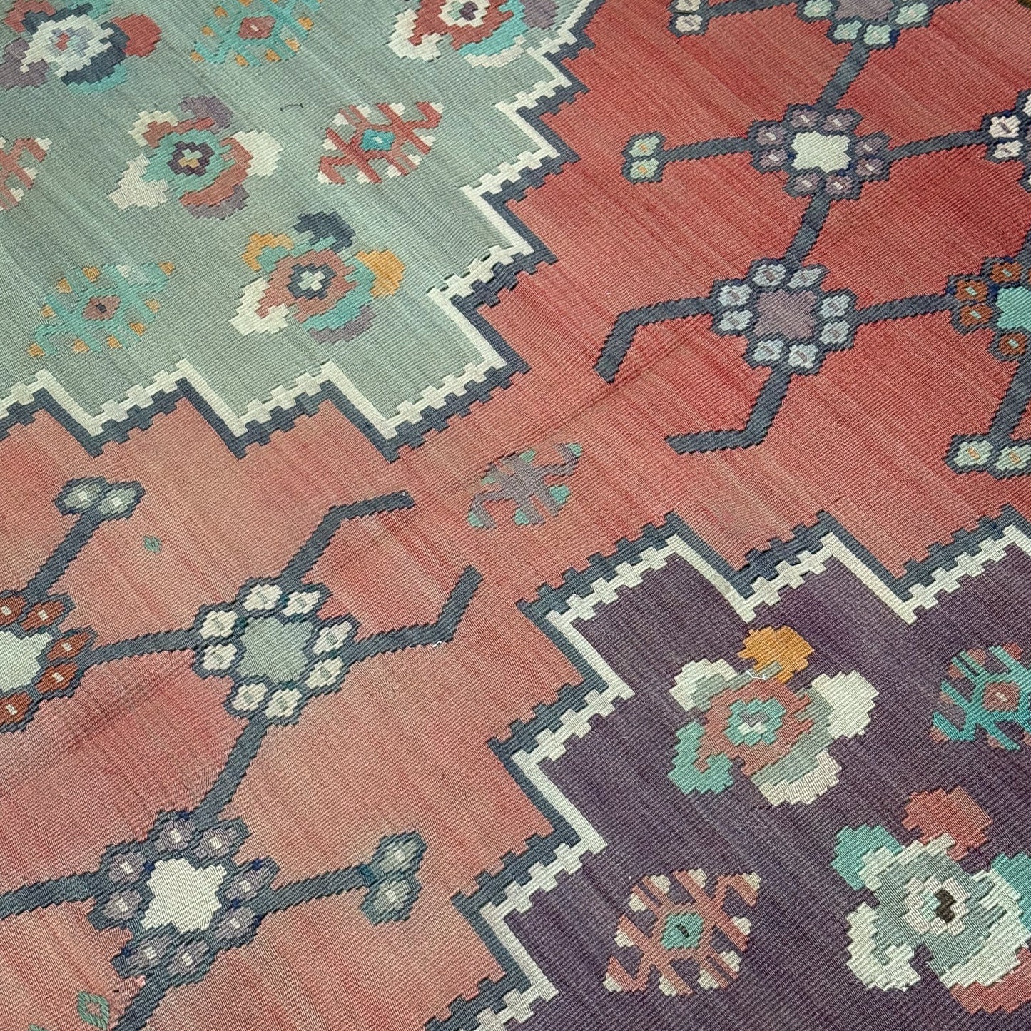 Close-up of a patterned rug with geometric designs and floral elements.