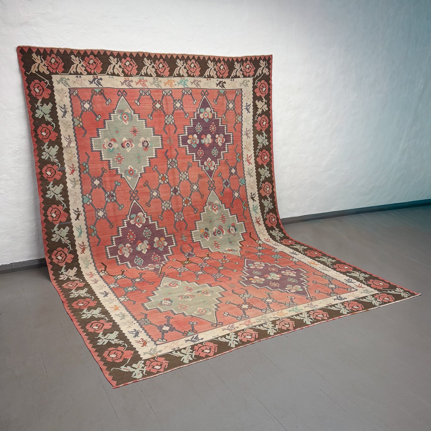 Decorative rug with intricate patterns on a plain floor.