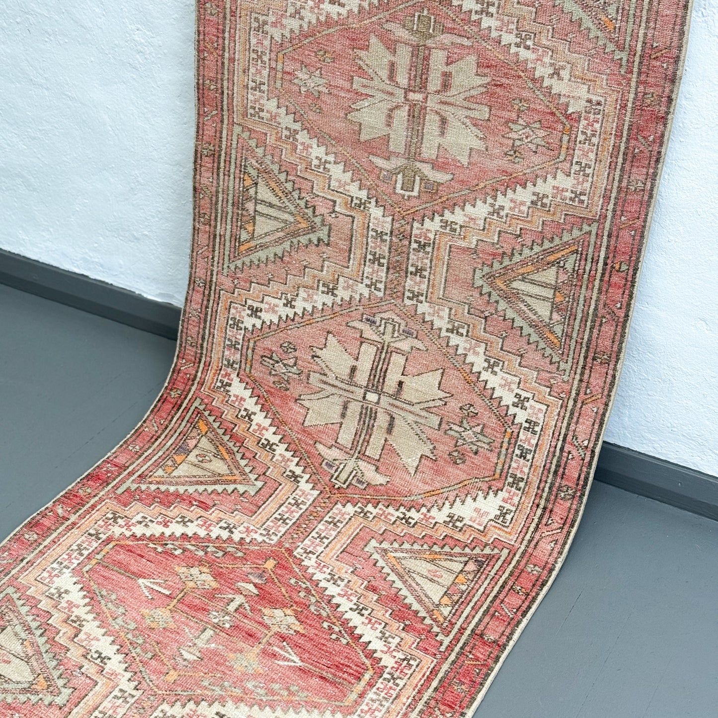 Patterned rug on a gray floor with a light blue wall background